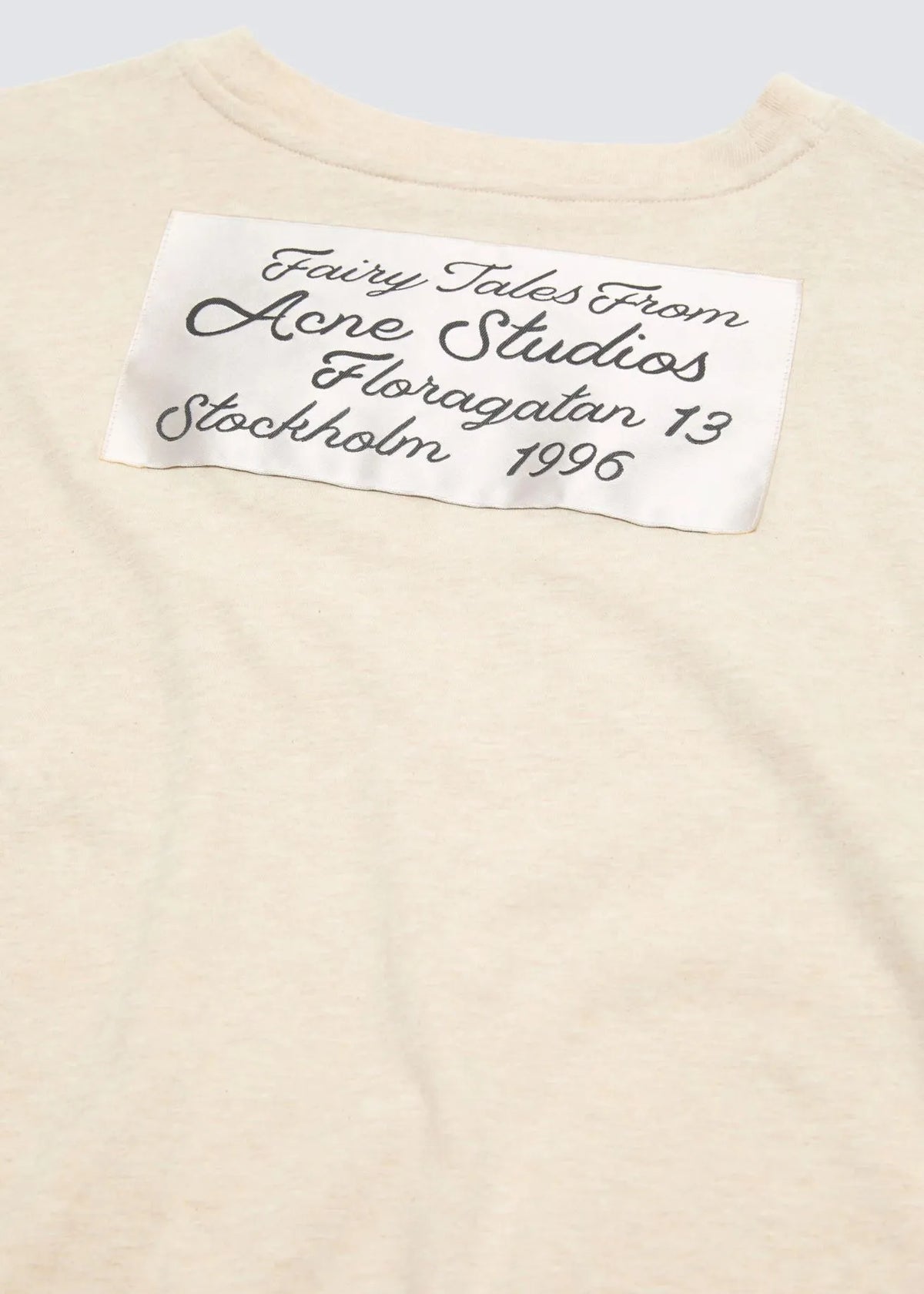 Nahaufnahme des gerafften Logos mit der Aufschrift: Fairy Tales from Acne Studios Floragatan 13 Stockholm 1996.