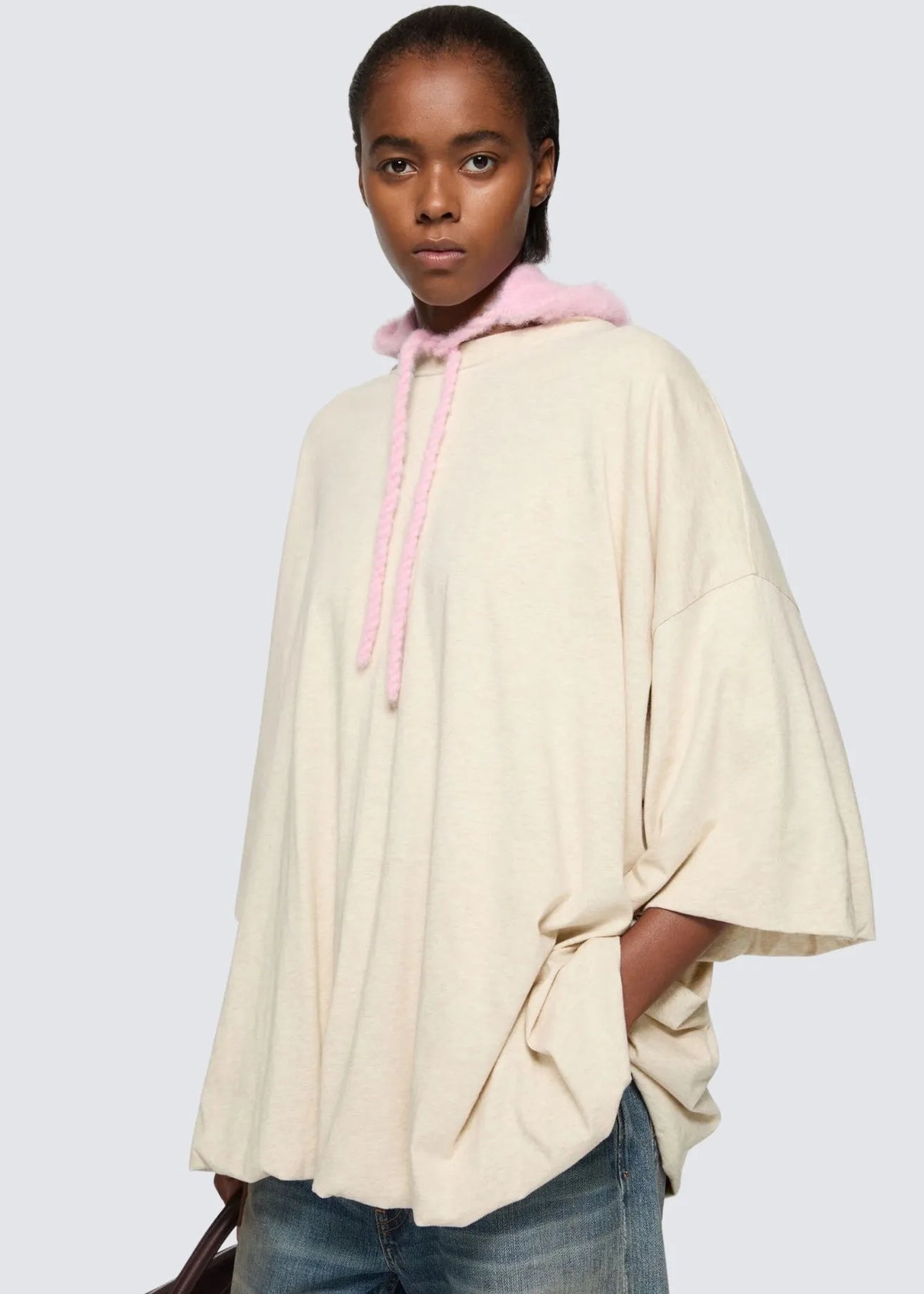 Nahaufnahme des Shirts in Beige von schräg vorne am Model.