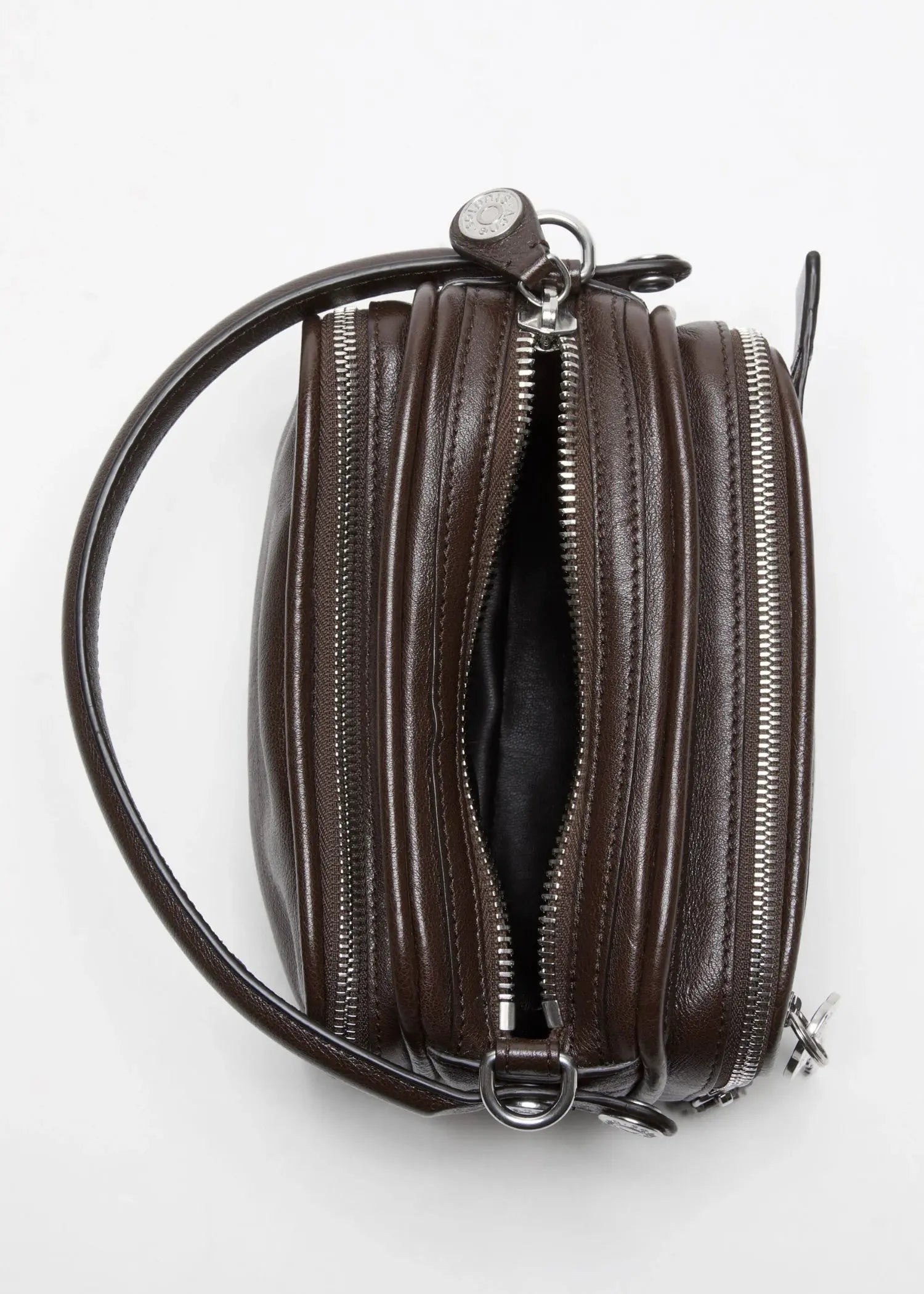 Acne Studios Camero Kit Handtasche in dunkelbraun mit Reißverschlüssen und Trage Riemen aus Kalbsleder, Studiofoto vor weißem Hintergrund mit Ansicht von oben