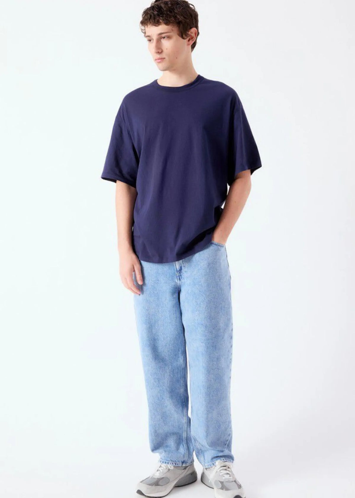 American Vintage Apoly T-Shirt getragen von einem Modell. Das Shirt ist dunkelblau und oversized.