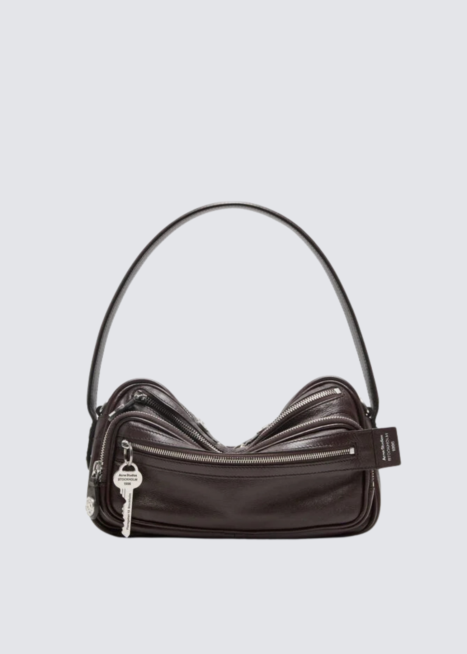 Glattleder Tasche in Braun mit kurzem Tragegriff, abnehmbarer Schulterriemen.
Großes Hauptfach mit Reißverschluss,
Reißverschluss-Fächer außen. Schlüsselanhänger sowie
Silberne Hardware. Flat Shot. 