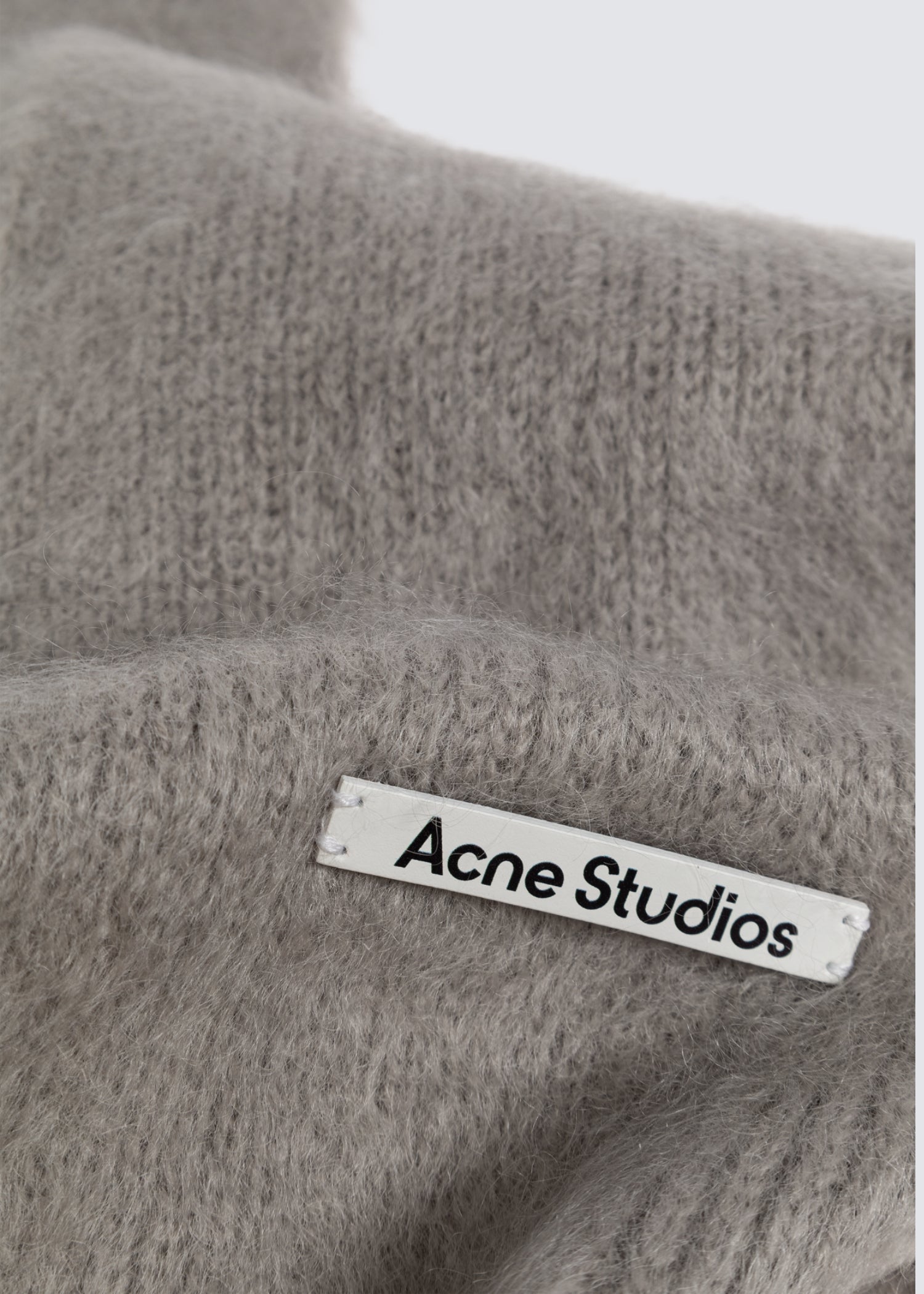 Grauer Mohair Kapuzen Schal mit Franse. Detail Shot, Logoetikett.