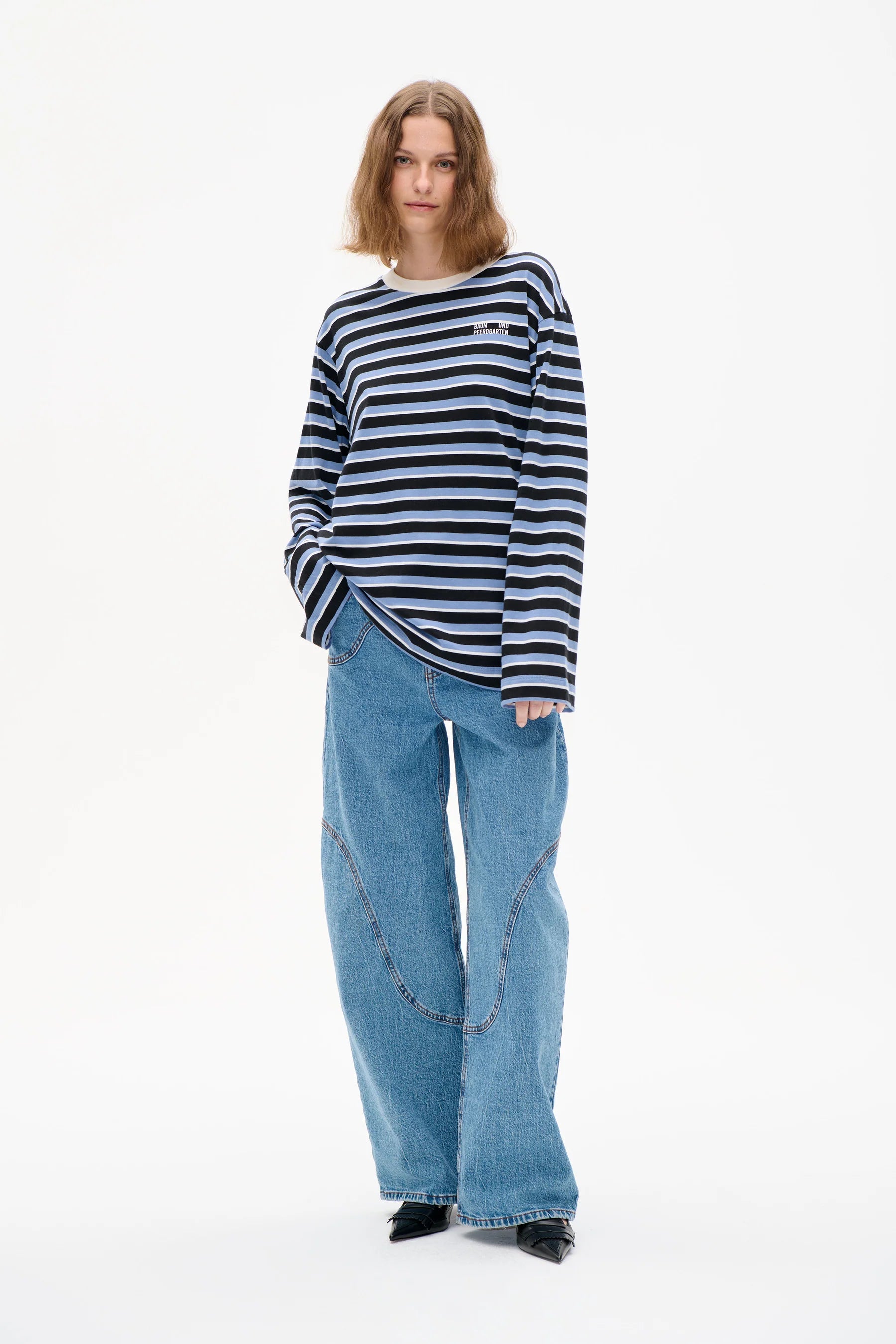 Blau gestreiftes Langarmshirt, mit Rundhalsausschnitt und aufgedrucktem Logo-Etikett. Model Bild.