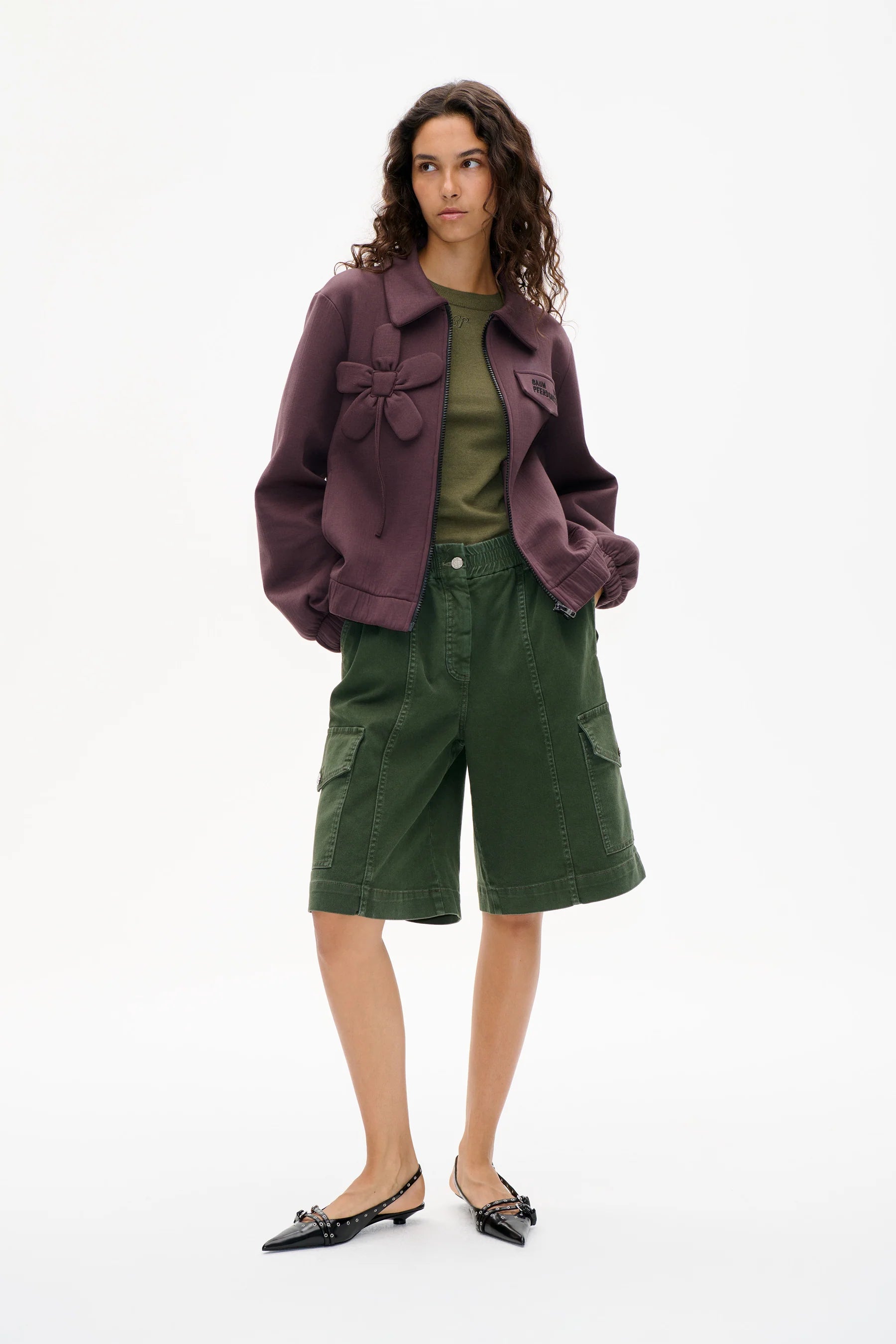 Burgunder Farbender Zipper, mit aufgenähtem Blumen Detail. Modelbild.