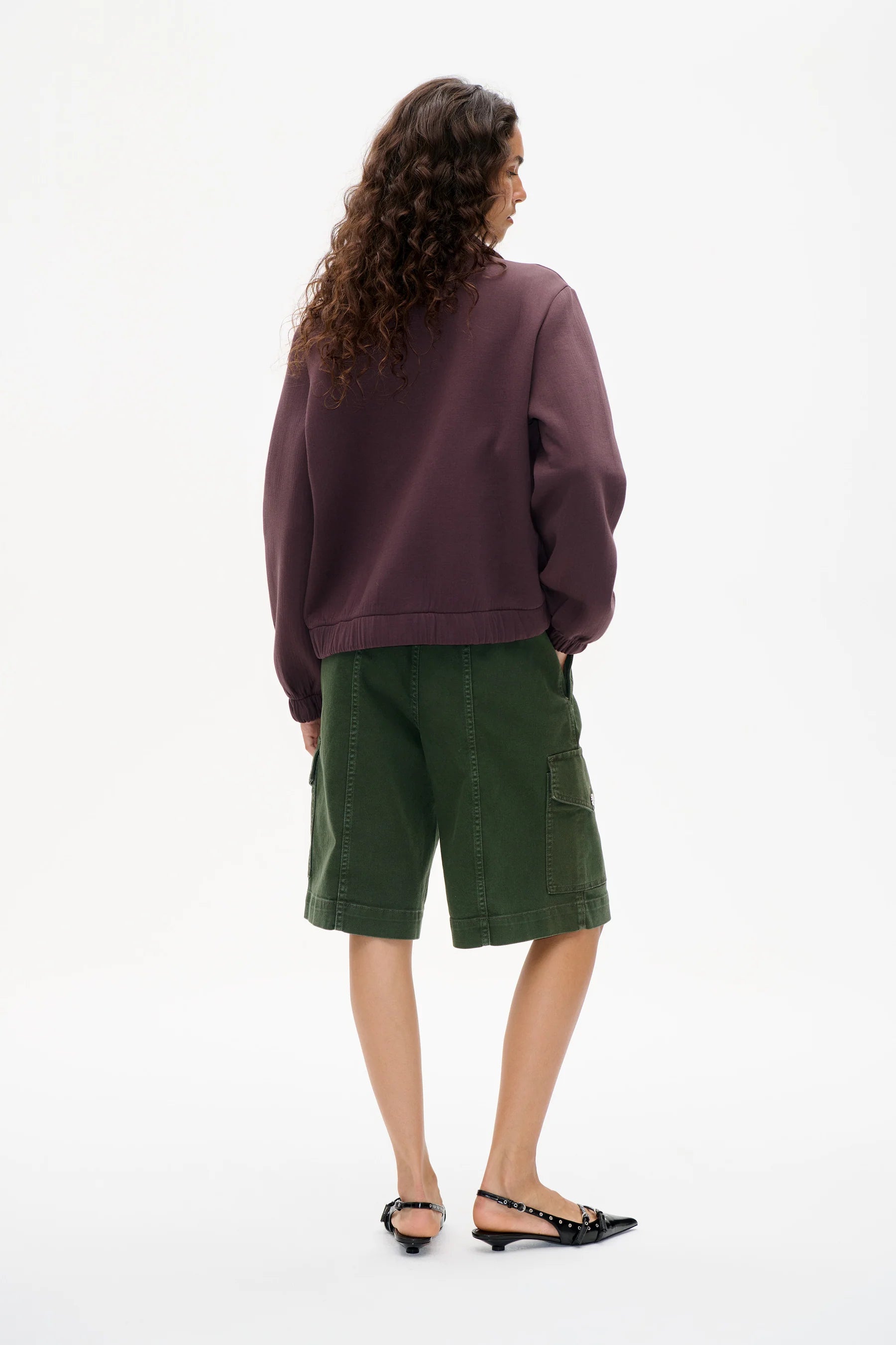 Burgunder Farbender Zipper, mit aufgenähtem Blumen Detail. Modelbild, Rückseite.