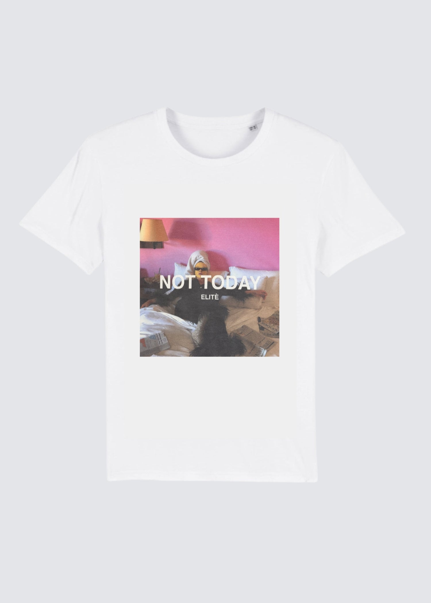 Auf dem Produktfoto sieht man ein weißes T-Shirt mit Rundhalsausschnitt und Print. Man sieht eine Frau die mit Turban und Sonnenbrille auf ihrem Bett liegt. 