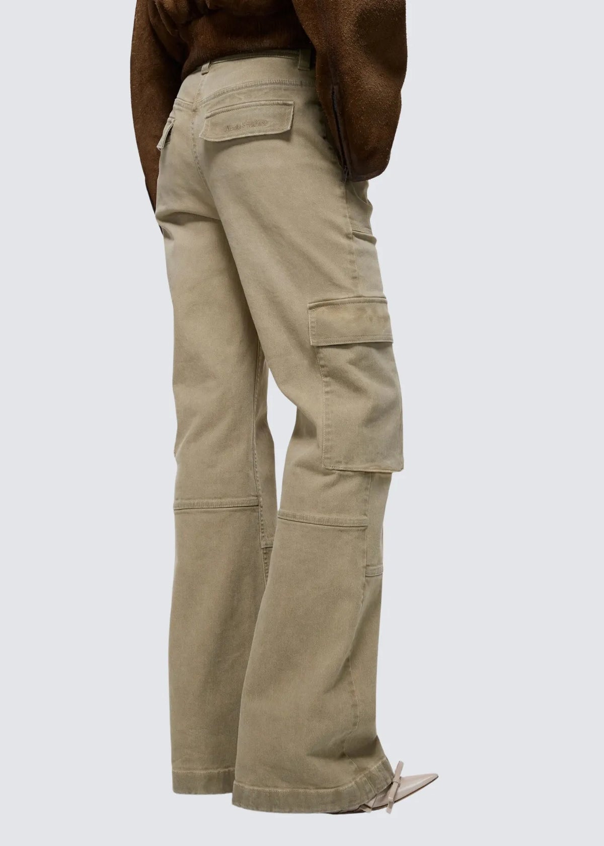 Modellfoto der Acne Hose von der Seite. Tasche außen am Bein und Hintertasche mit Acne Studios Stickerei.