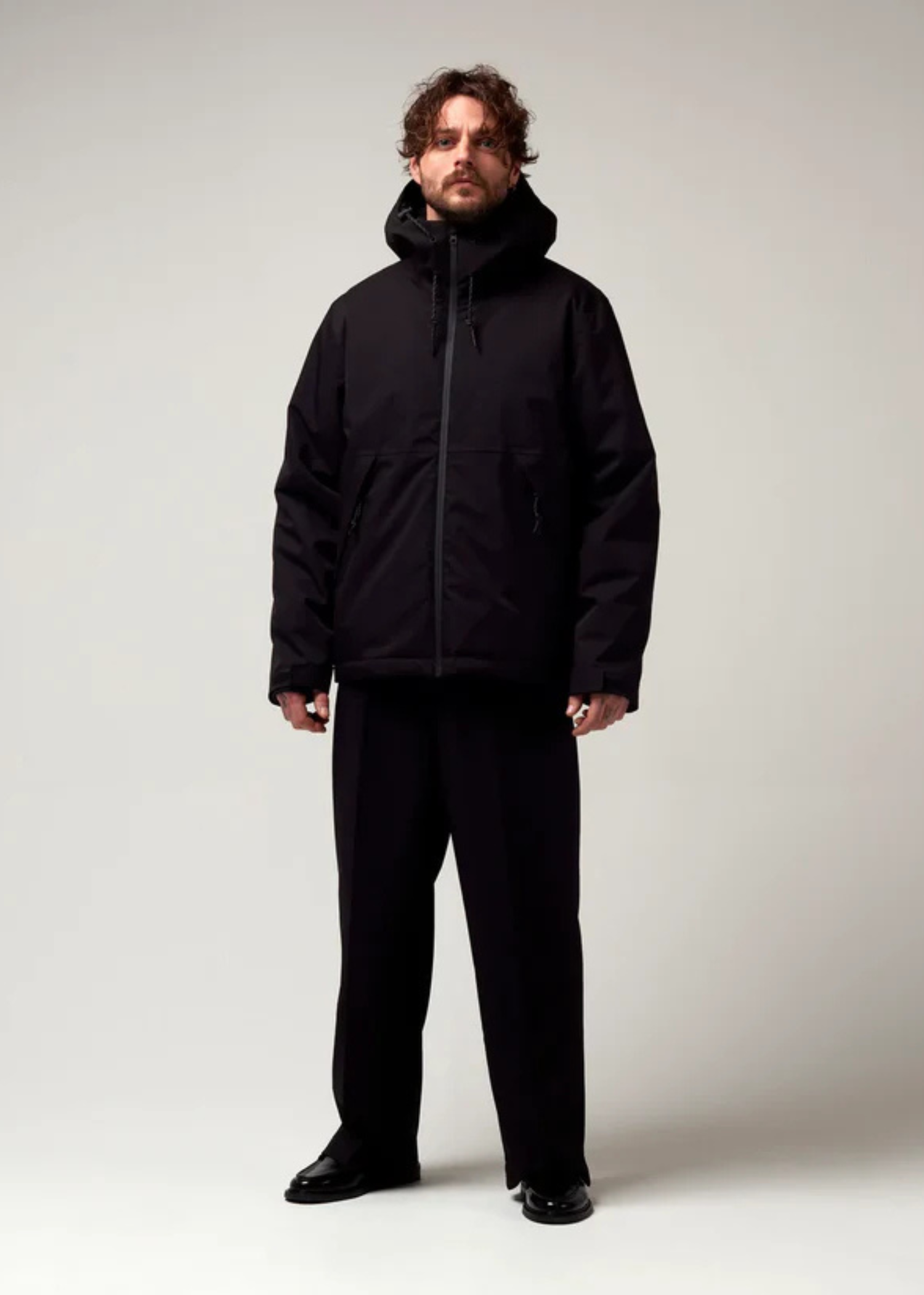 Kurz geschnittene Schwarze Jacke, mit verstellbarer Kapuze, seitlichen Jacke Taschen sowie schwarzer Hardware. Saum an den Ärmeln mit Daumen Loch. Model Bild.