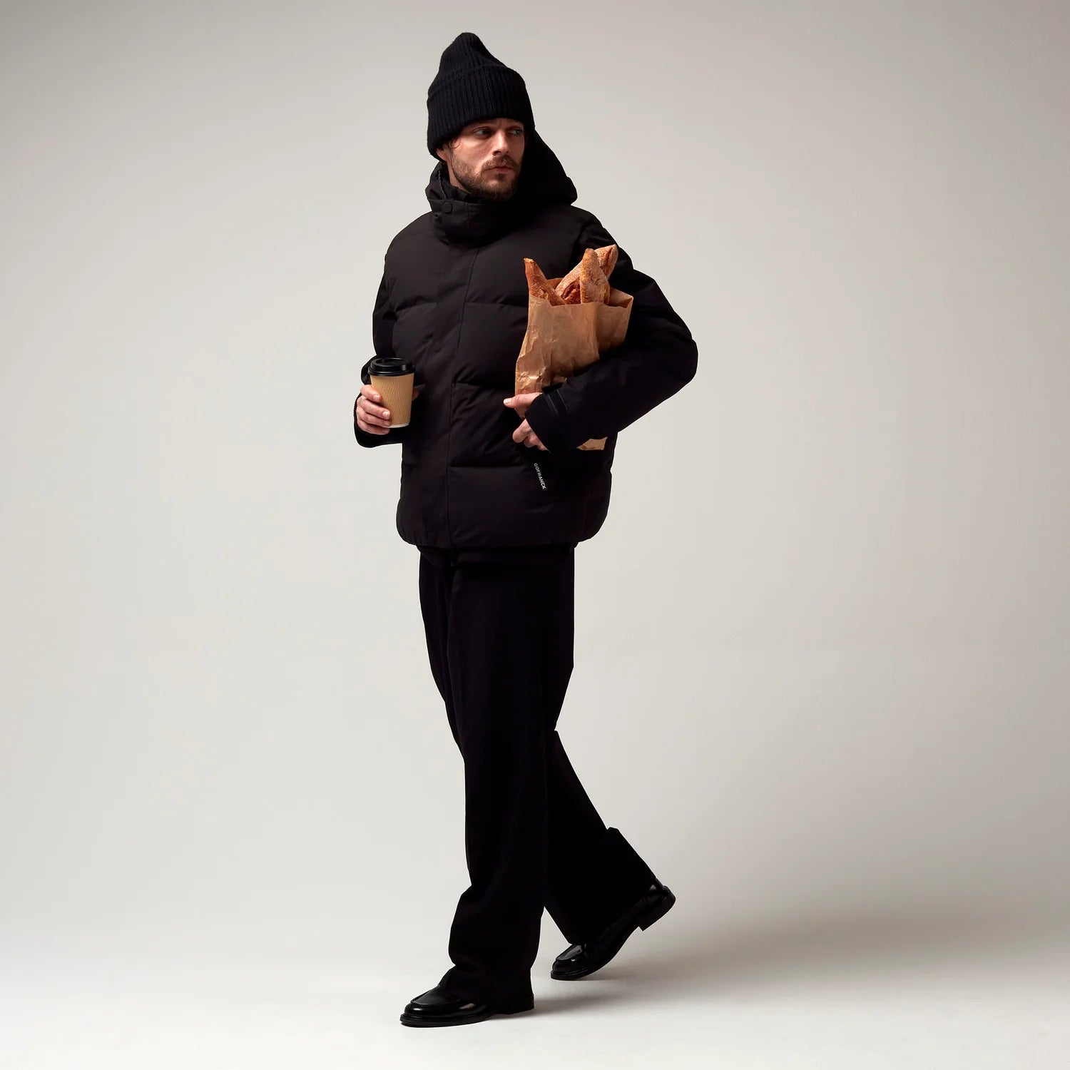 Kurz geschnittene Schwarze Jacke, mit verstellbarer Kapuze, seitlichen Jacke Taschen sowie schwarzer Hardware. Saum an den Ärmeln mit Daumen Loch. Dazugehörige schwarze Steppweste über der bereist beschrieben Jacke. Model Bild.