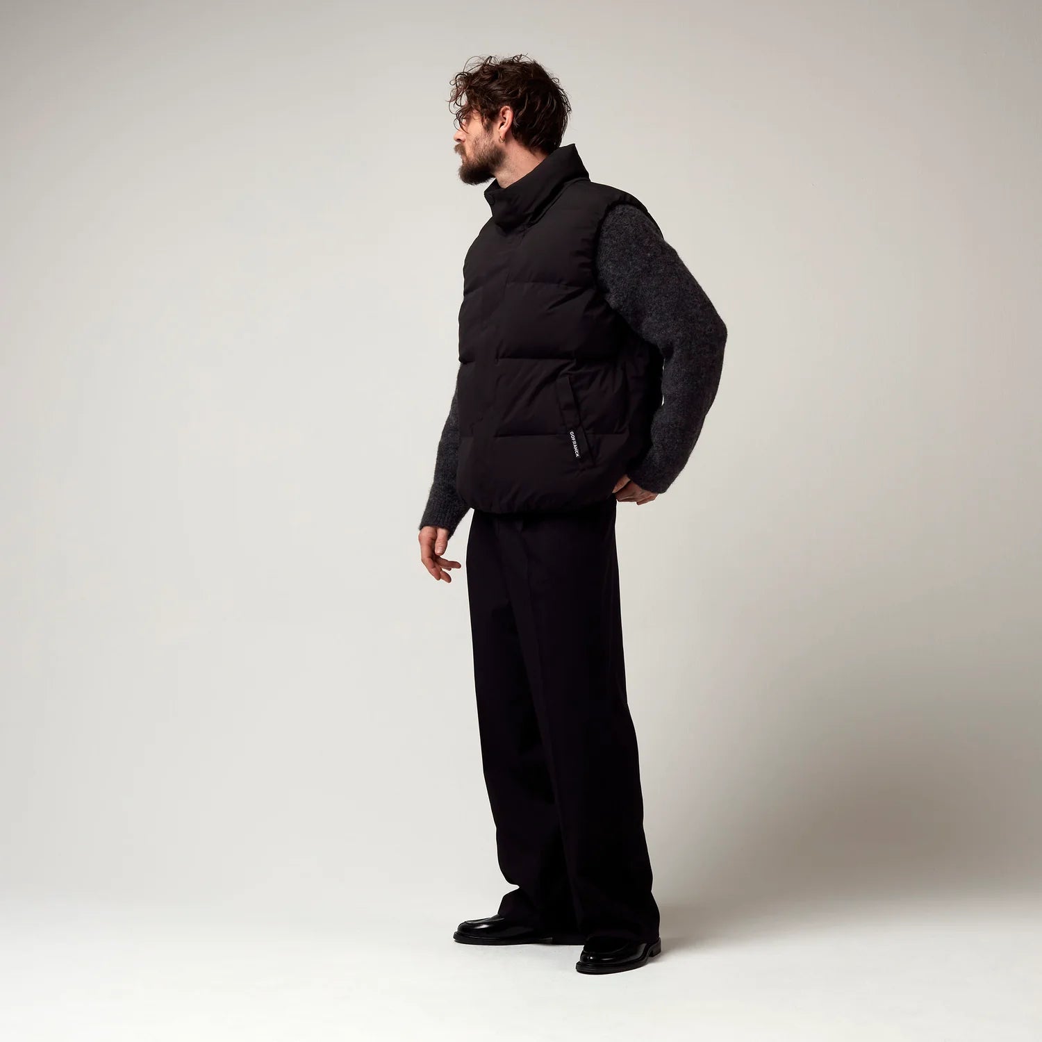 Schwarze Steppweste mit Logo Etikett der Marke Go Frank. Model Bild.