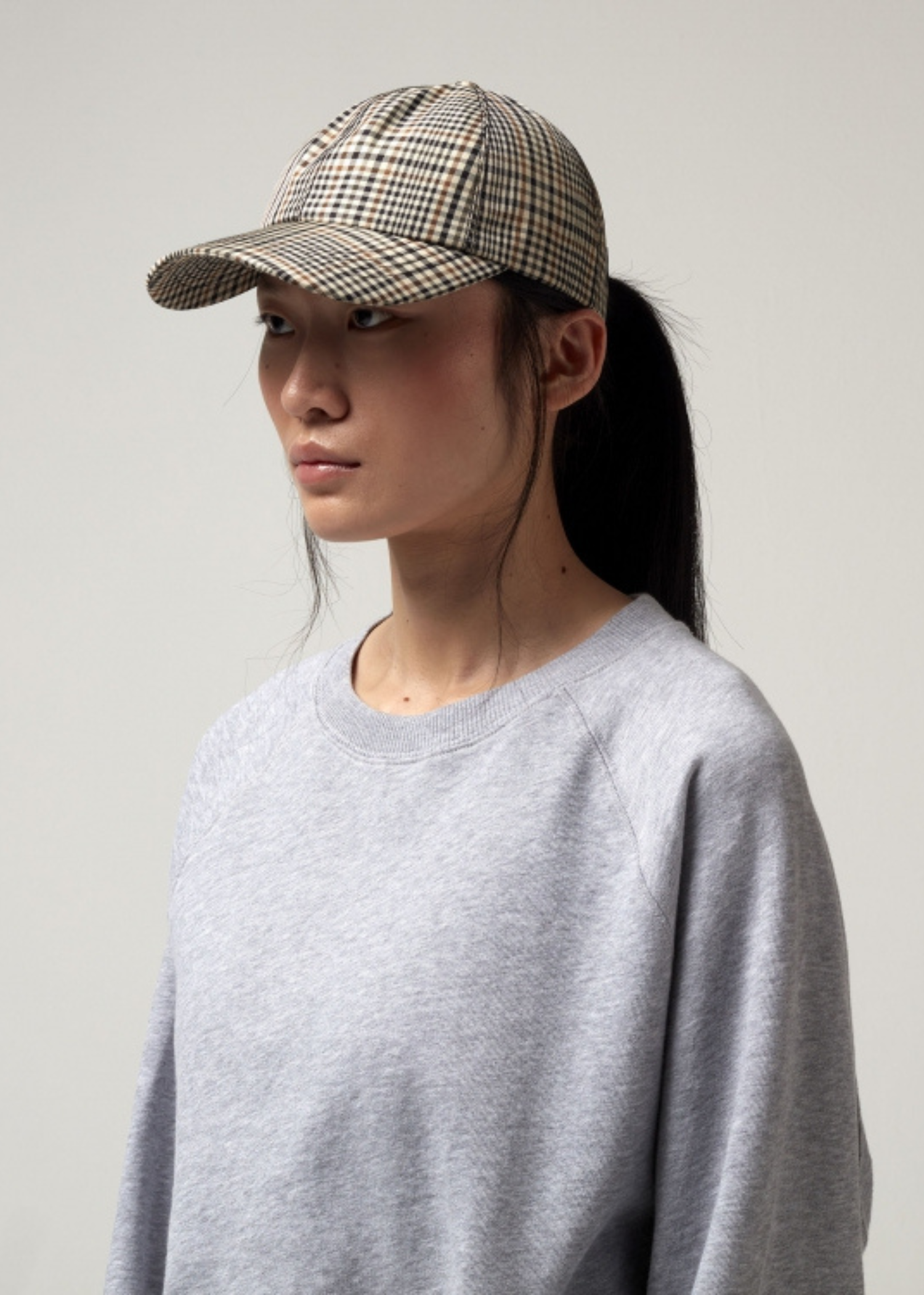 Größenverstellbare Kappe. Kariert in Beige/Braun Farben. Model Bild.