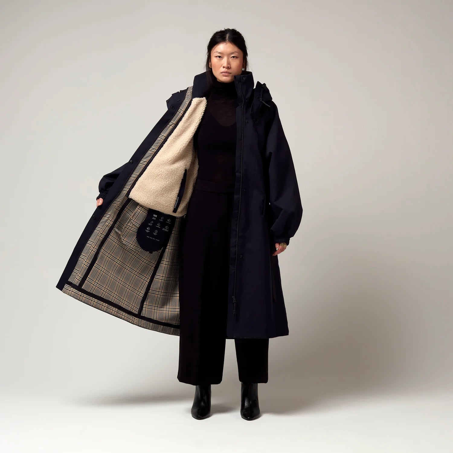 Dunkel Blauer Parker, mit Verstellbarer sowie abnehmbarer Kapuze, Geöffnete Jacke, Innenjacke geöffnet, Innenfutter aus Fell erkennbar. Karo Muster sowie Innentaschen erkennbar. Model Bild, Ganzkörper Aufnahme.