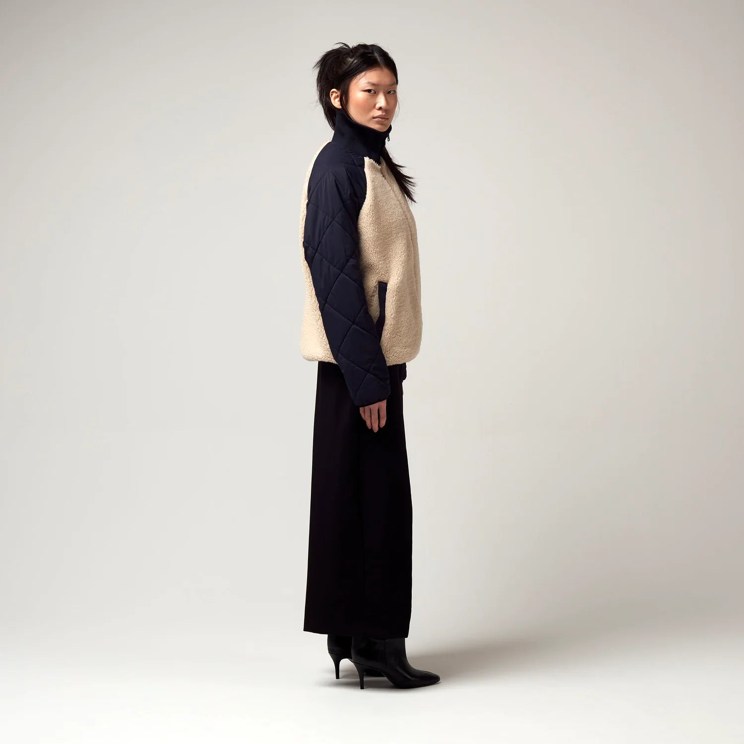 Innenjacke des Dunkel Blauen Parkers, bestehend aus einer wende Bomberjacke. Gefütterte Aussenseite zu erkenne, in dunkel Blau sowie taupe Farbenden Fell. Model Foto seitliche Ansicht.