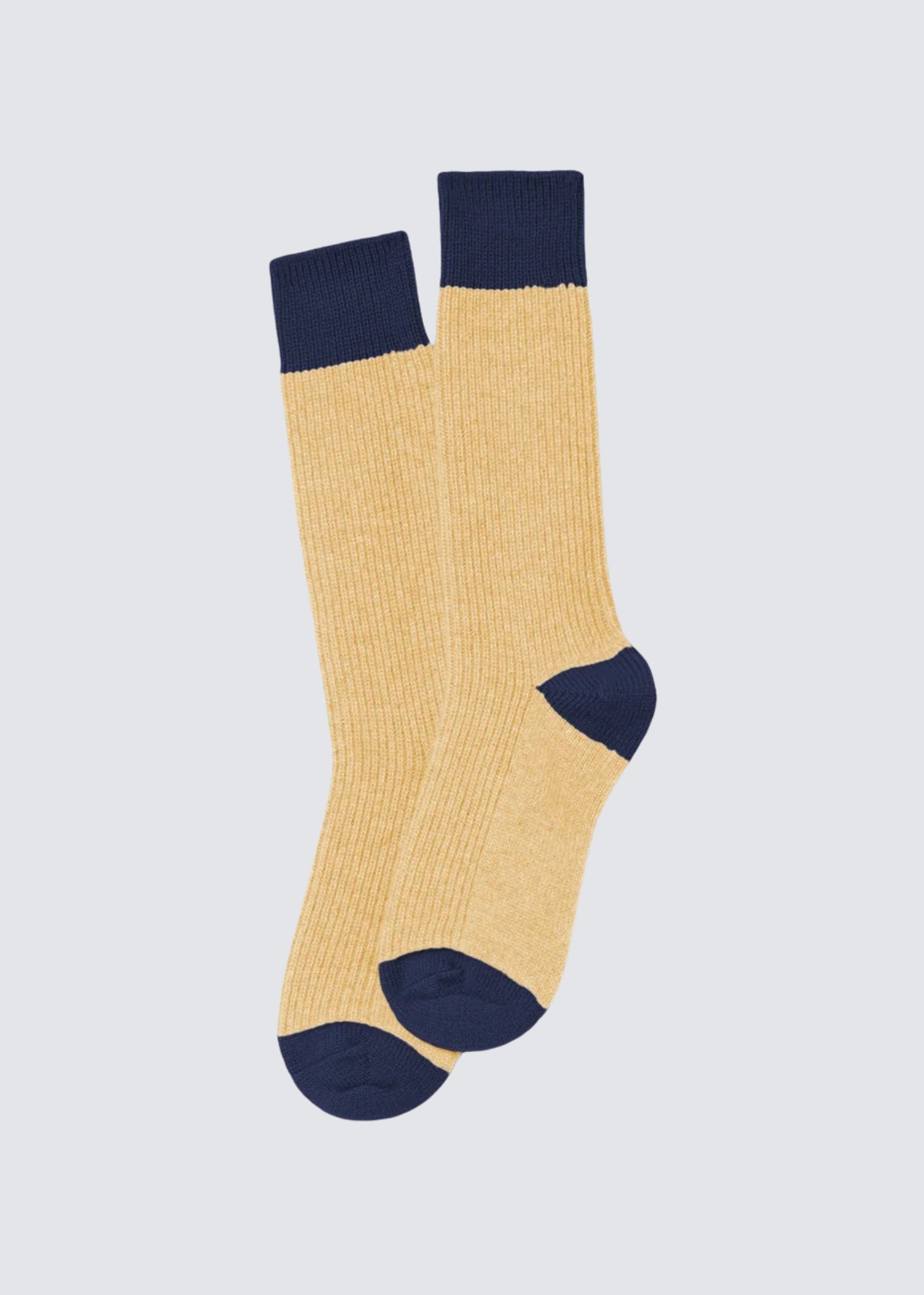 Guest in Residence Strümpfe aus Kaschmir in butter yellow, mit dunkel blauen Bund im colorblocking stil. Flat shot.