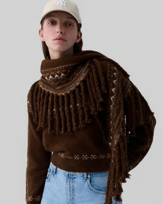 Dunkelbrauner Dreiecksschal, mit eingedrehten Fransen und Musterung entlang der Enden. Model Bild.