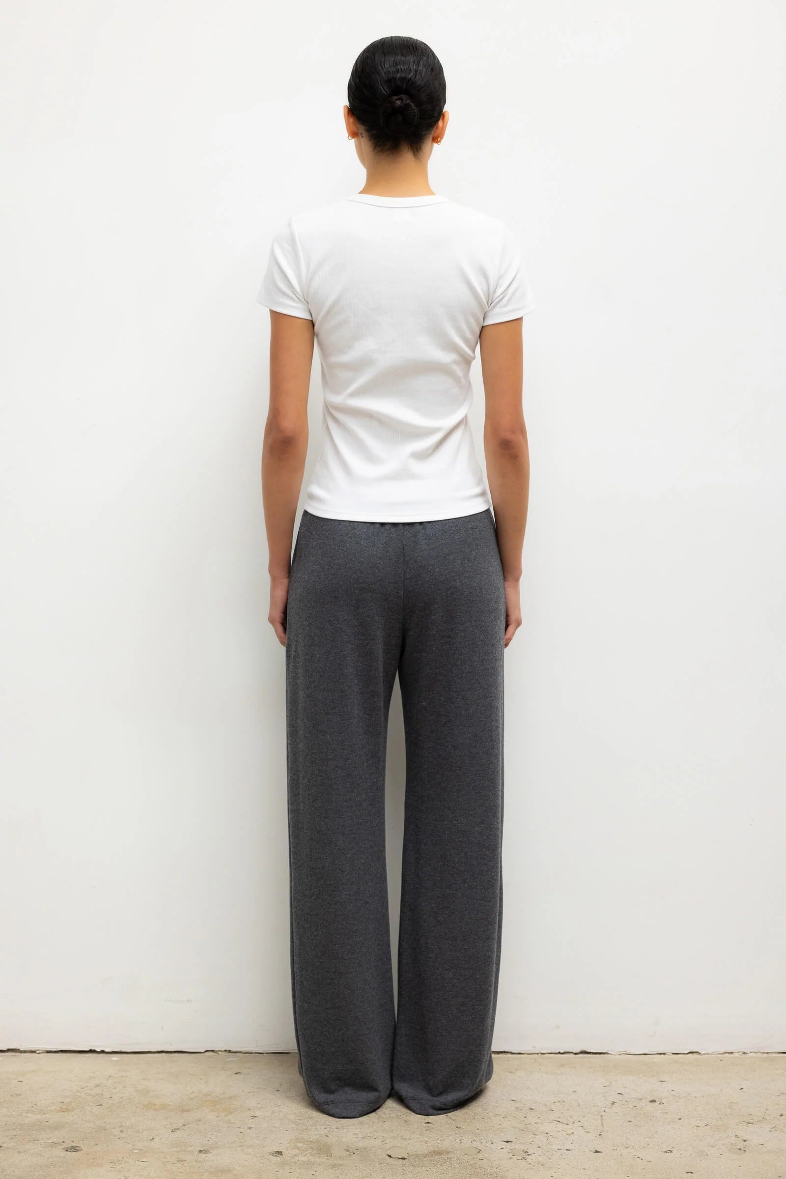Das Model trägt das Kelly Shirt mit Rundhalsausschnitt von Leset in weiß. Rückansicht in der Totalen. 