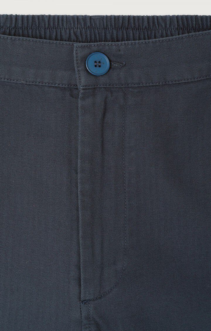 Detailfoto der Bundpartie. Man sieht einen Knopf und mit Stoff verdecktem Reißverschluss