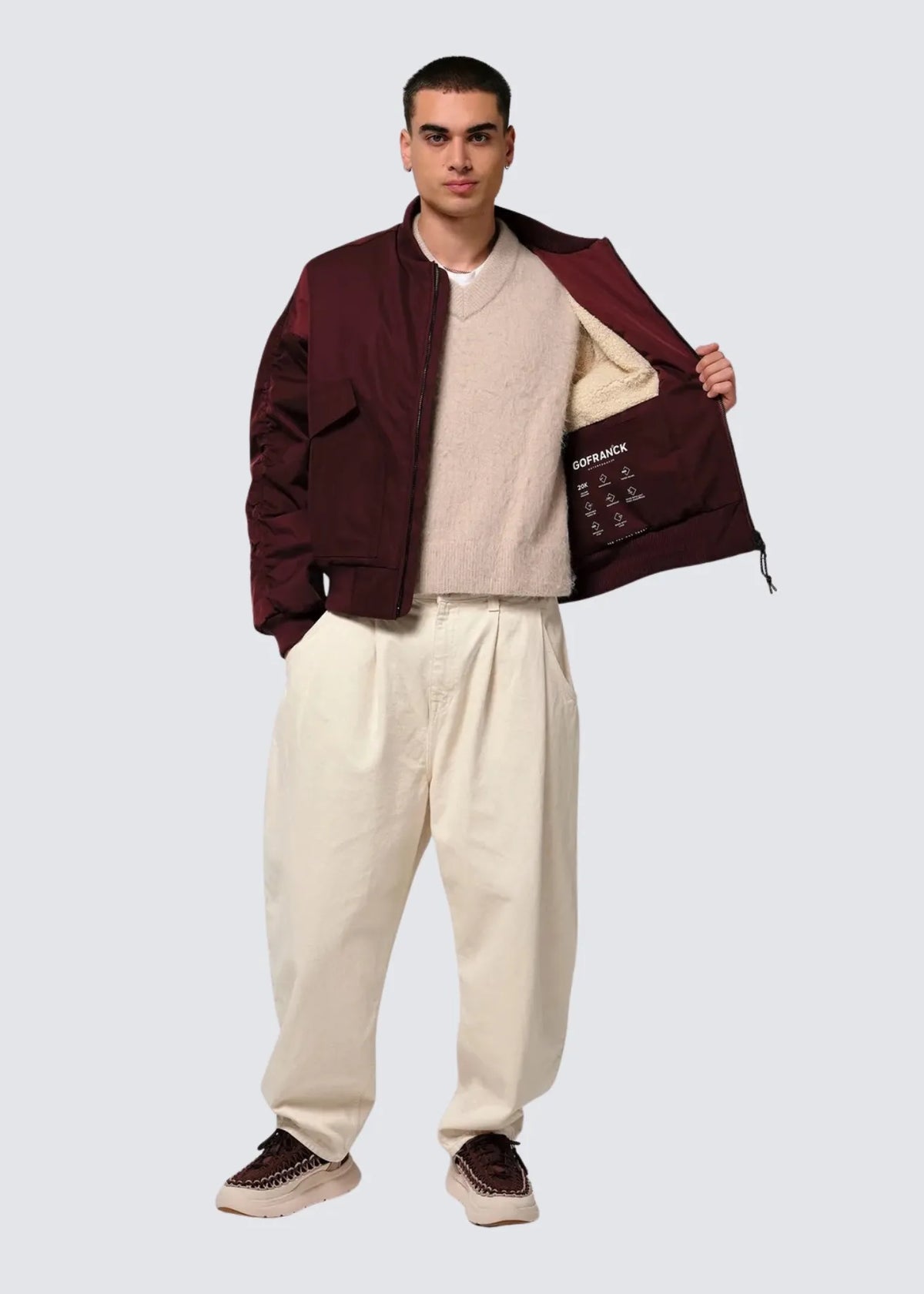 Hier sieht man wie das Modell die Jacke offen trägt und die linke Seite nach hinten zieht. So hat man einen lick auf die Innentasche sowie das Sherpa Fell womit die Jacke gefüttert ist.