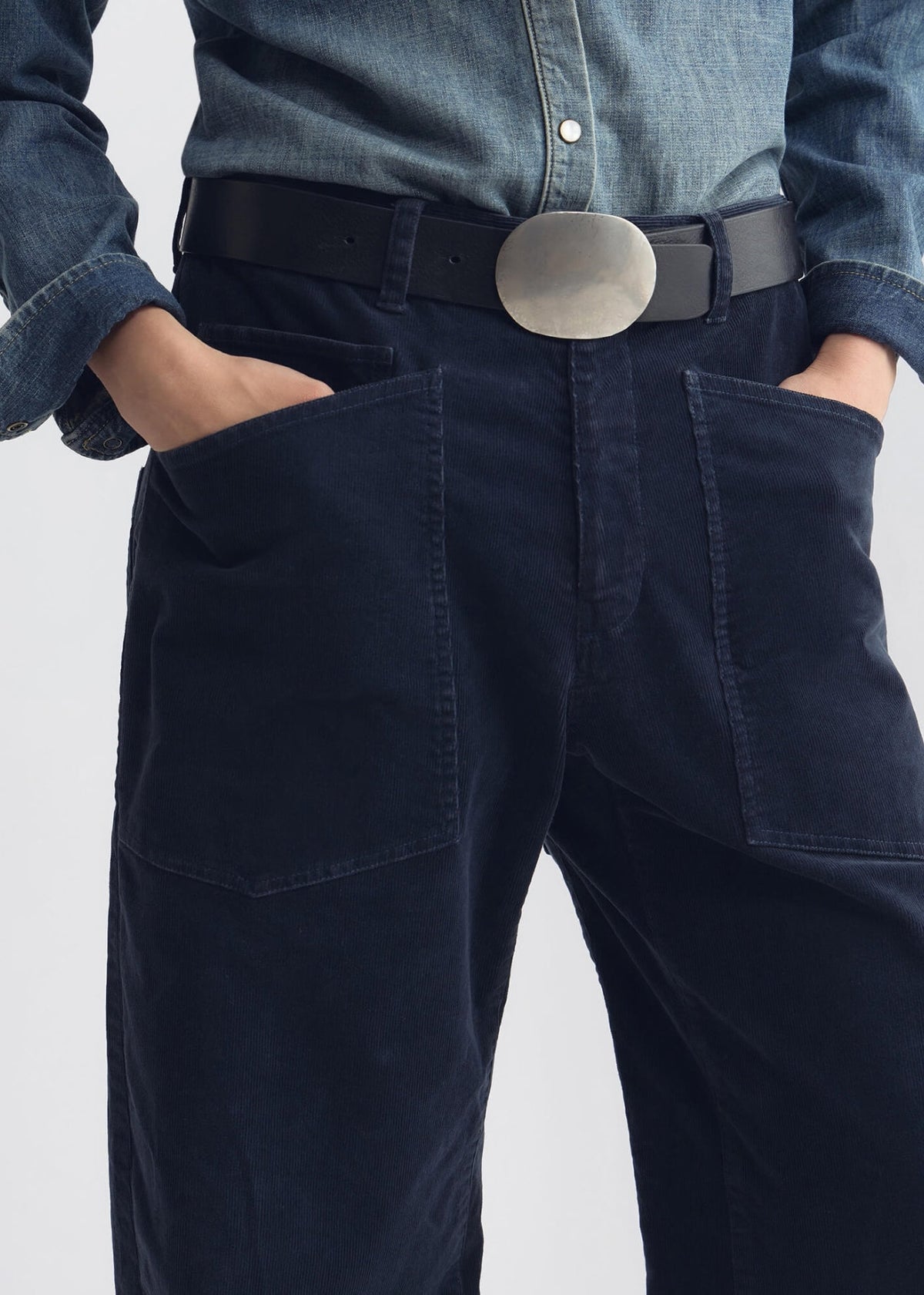 Nahaufnahme der getragenen Hose mit Händen in den aufgenähten Taschen.
