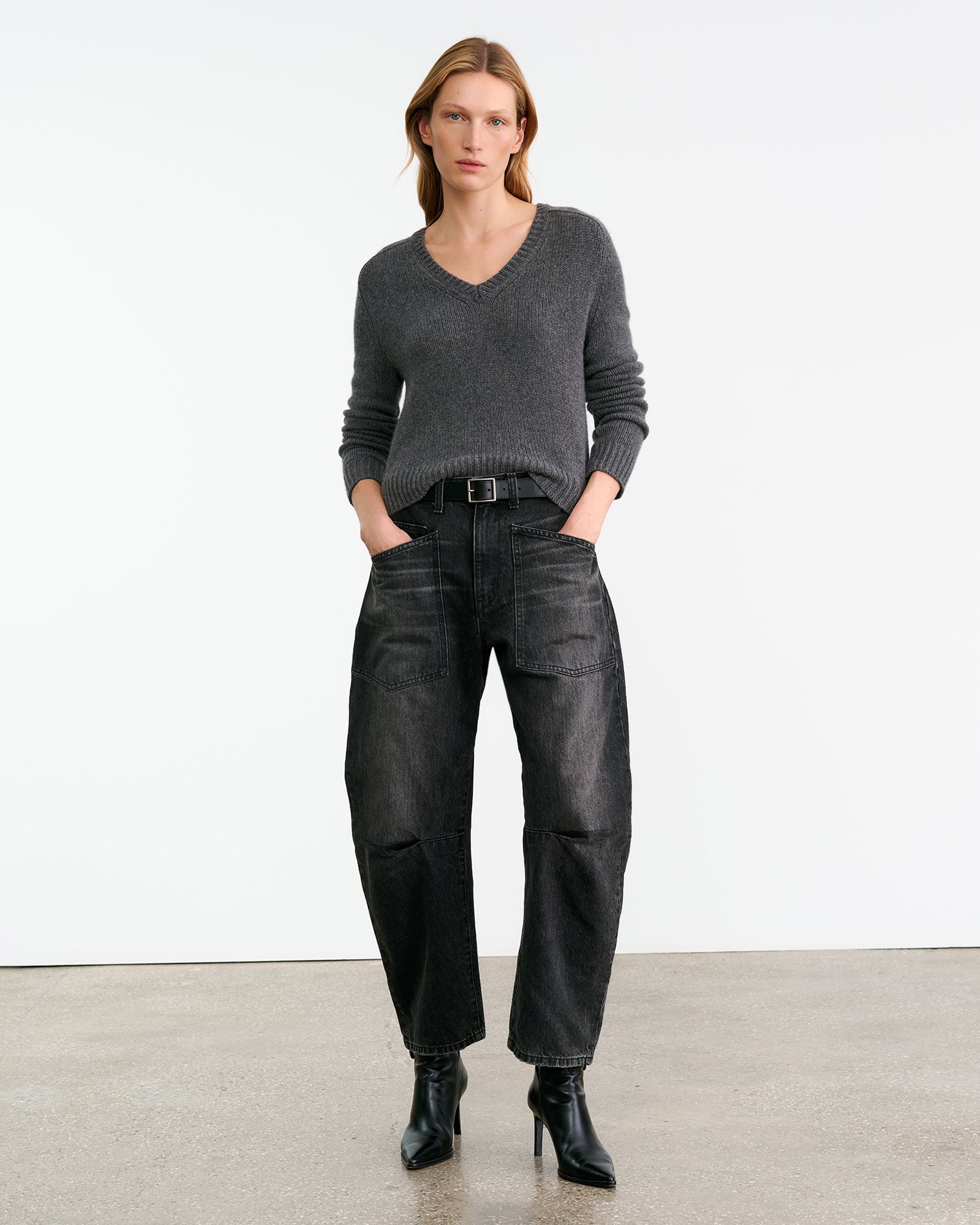 Graue Mid Rise Jeans mit rund geschnittenen Bein und aufgesetzten Taschen. Model Foto.