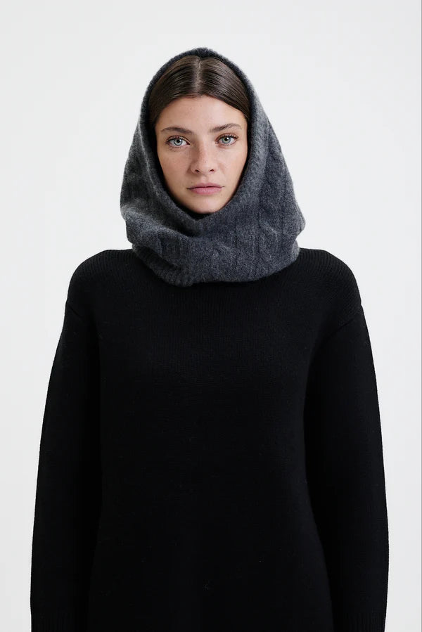 Prinz Berlin Kaschmir Balaklava in graphite mit Rippenstrick Optik. Das Model trägt die Balaklava zusammen mit einem schwarzen Pullover. Portrait des Models.