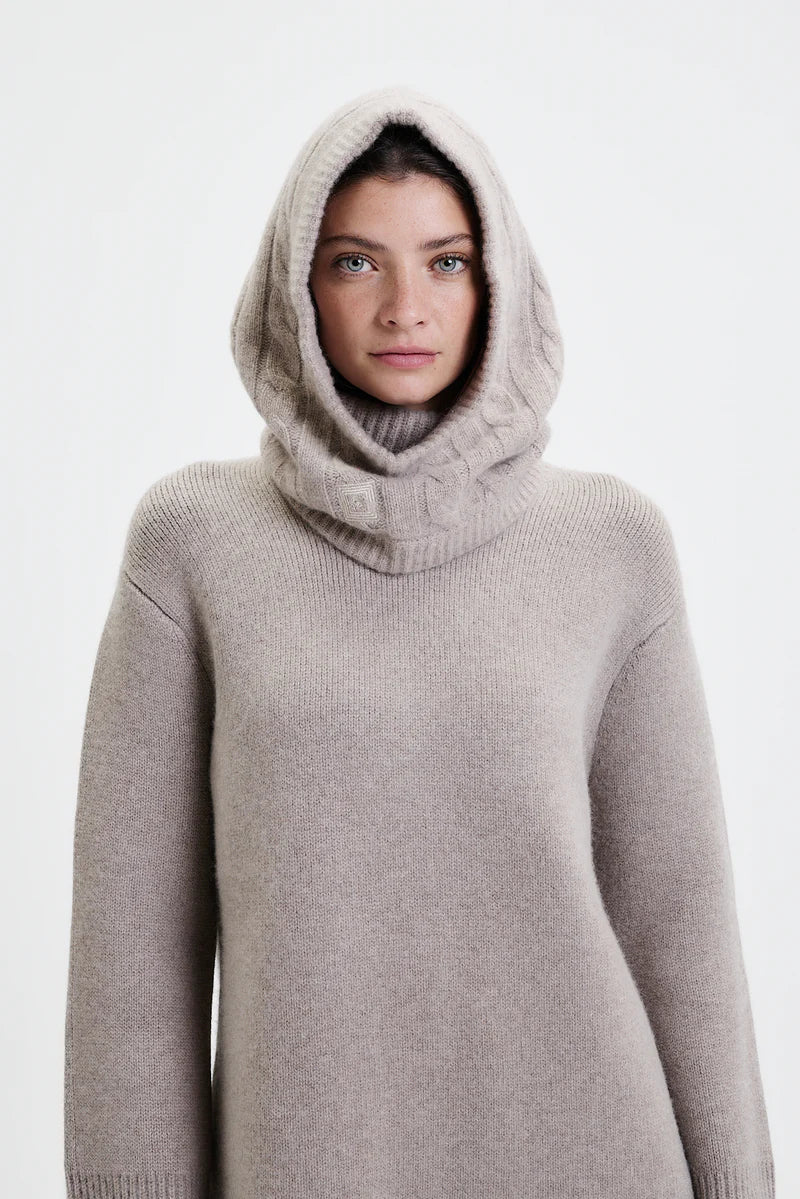 Prinz Berlin Kaschmir Balaklava in taupe mit Rippenstrick Optik. Das Model trägt die Balaklava zusammen mit einem beigen Pullover. Portrait des Models.