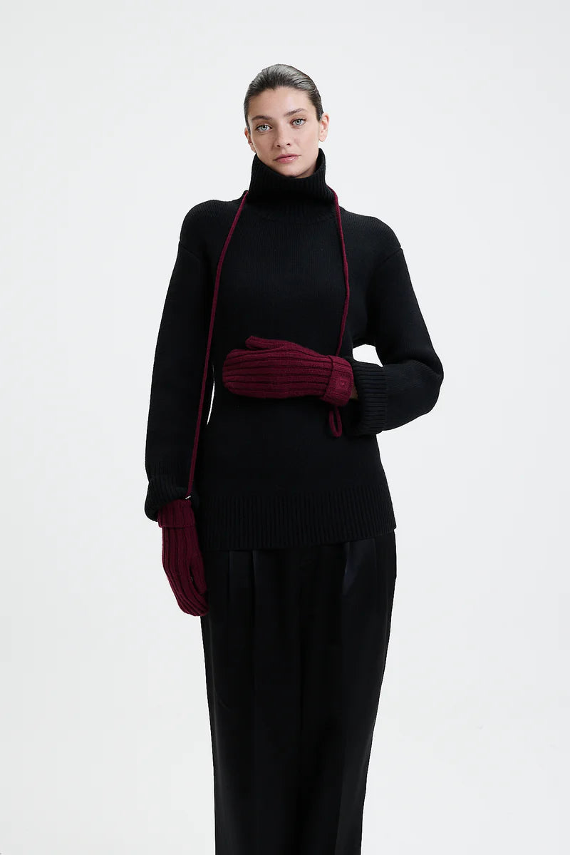 Prinz Berlin bordeaux Mittens mit Rippenstrick. Model trägt die Handschuhe und hat die Kordel um den Hals gebunden. Portrait Ansicht des Models.