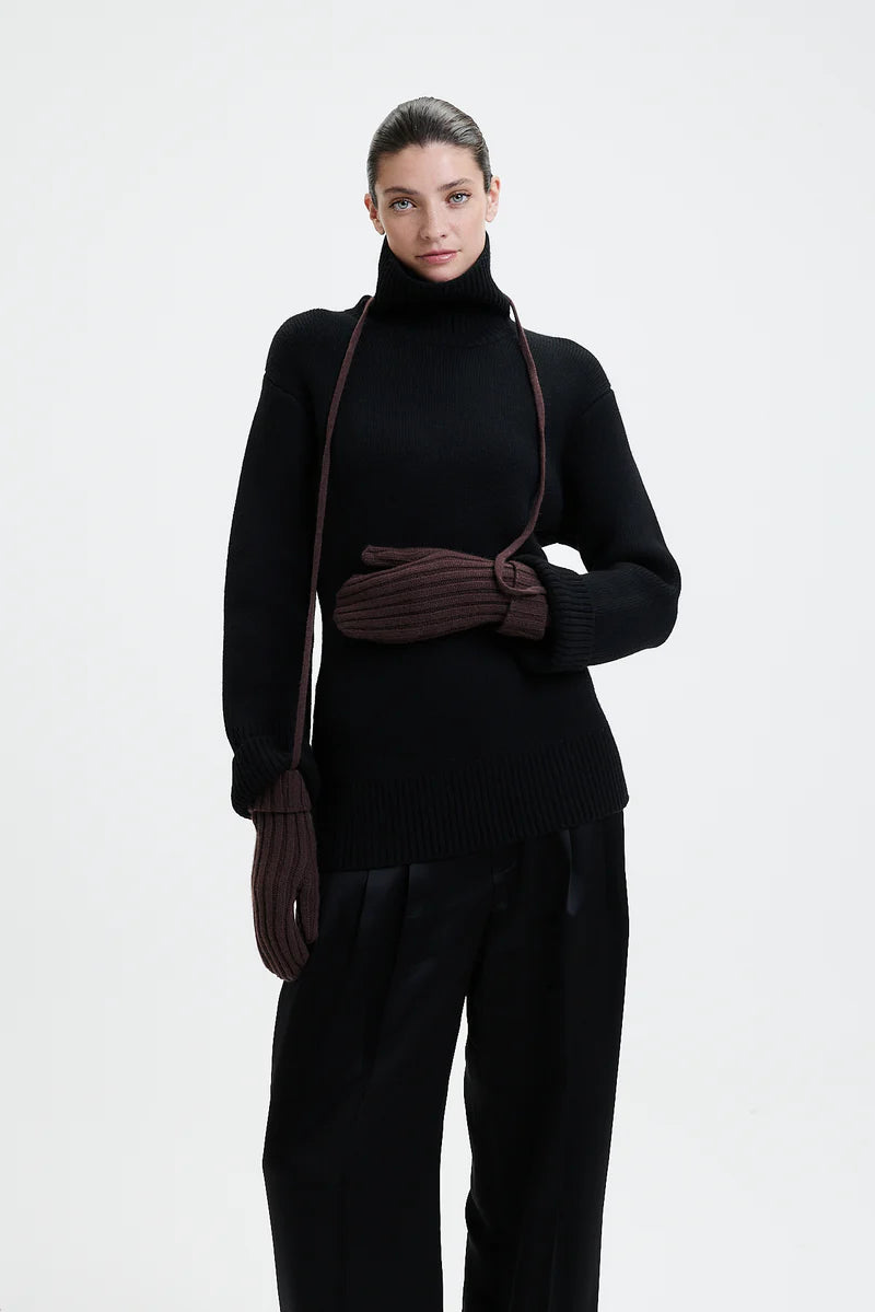 Prinz Berlin braune Mittens mit Rippenstrick. Model trägt die Handschuhe und hat die Kordel um den Hals gebunden. Portrait Ansicht des Models.