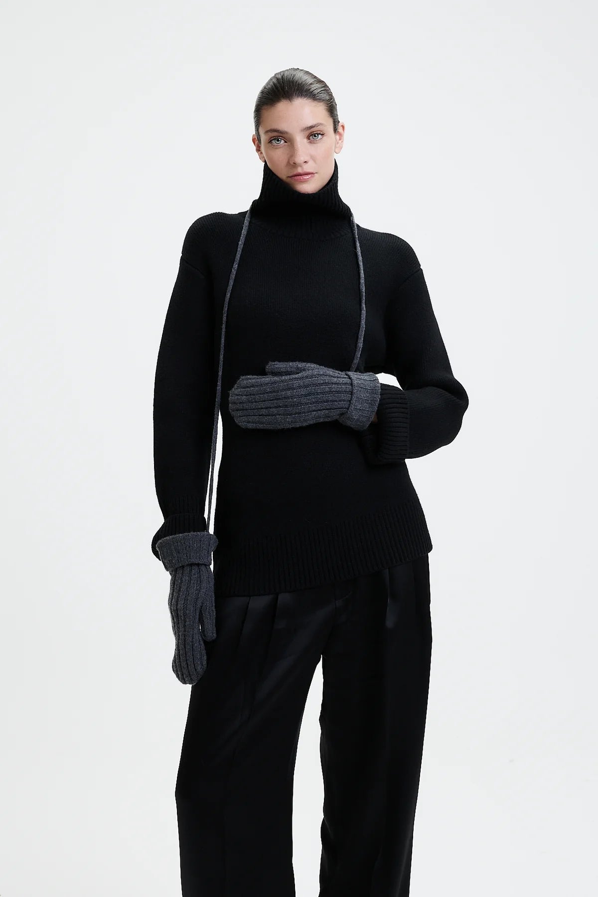 Prinz Berlin graphite Mittens mit Rippenstrick. Model trägt die Handschuhe und hat die Kordel um den Hals gebunden. Portrait Ansicht des Models.