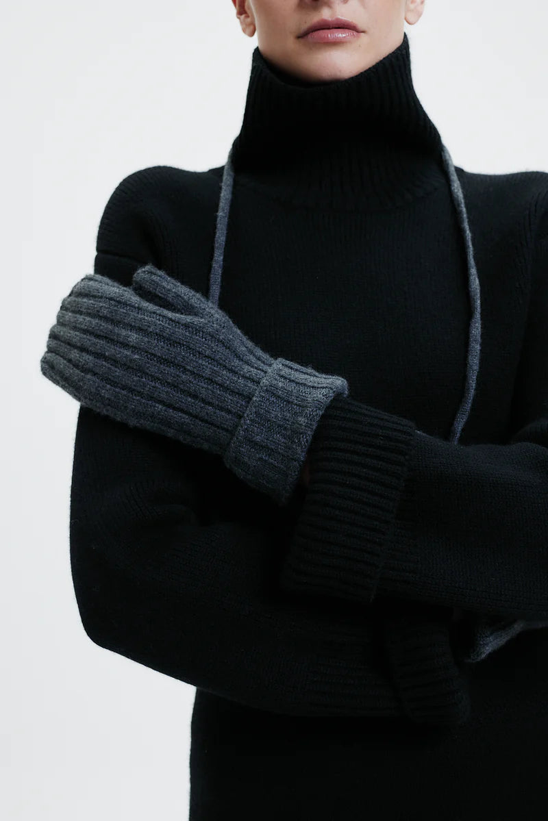 Prinz Berlin graphite Mittens mit Rippenstrick. Model trägt die Handschuhe und hat die Kordel um den Hals gebunden. Portrait Ansicht des Models.