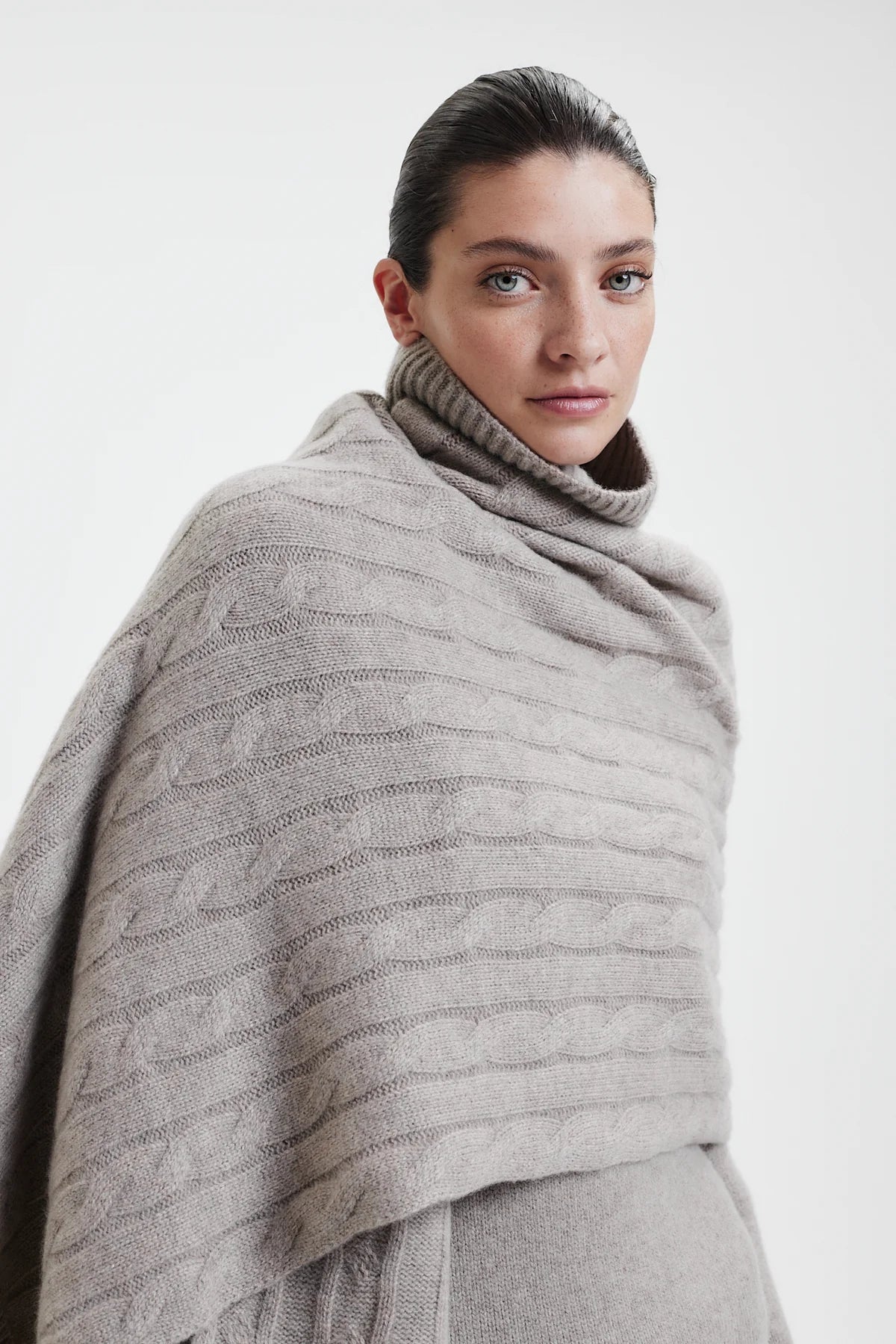 Prinz Berlin taupe Kaschmir Schal mit Rippenstrick Optik. Das Model trägt den Schal locker gebunden, um den gesamten Schulter und Brustbereich.
 Portrait des Models.