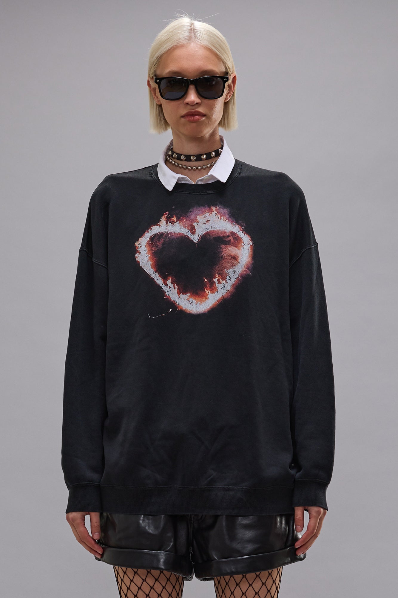 Longsleeve aus schwarzer Baumwolle, mit buntem brennenden Herz print. Lockere Passform mit Rundhalsausschnitt. Model Bild.