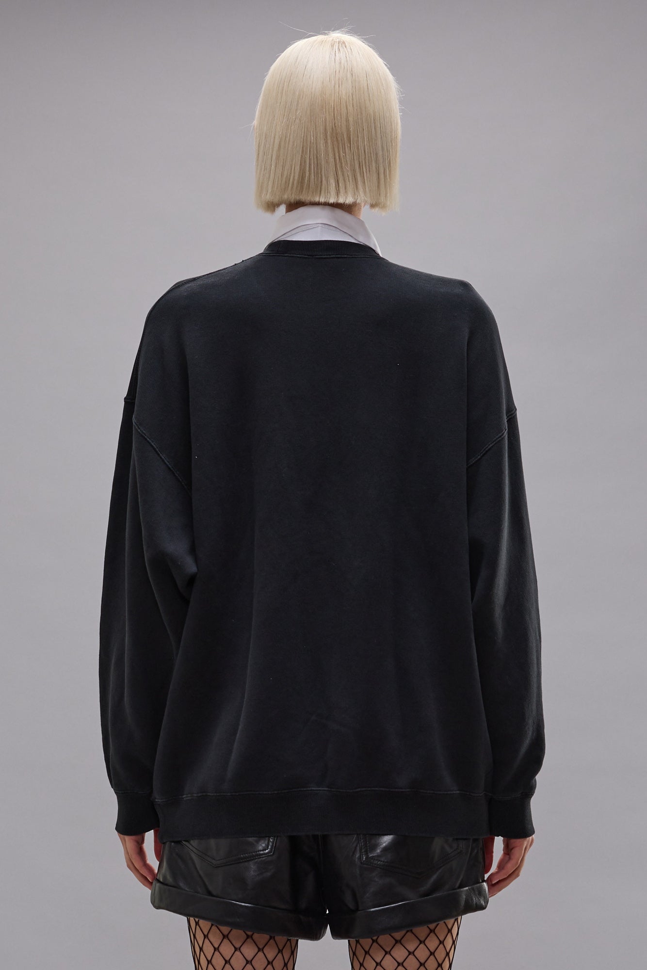 Longsleeve aus schwarzer Baumwolle. Lockere Passform mit Rundhalsausschnitt. Model Bild, Rückseite.