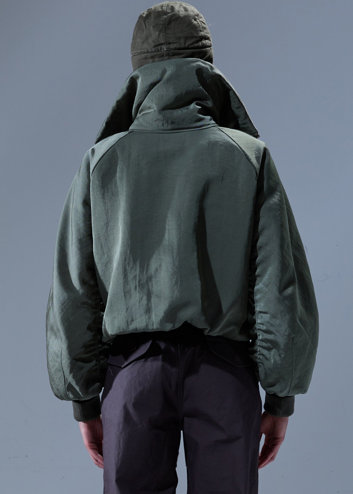 Khaki Farbende Bomberjacke mit Stehkragen. Model Bild, Hinter Ansicht.