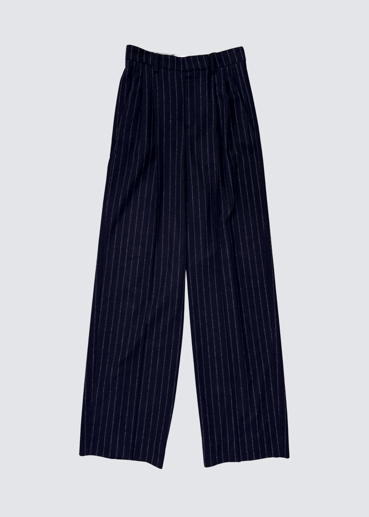 Unisex Hose aus Wollgemisch in Marine Blau und Weiß gestreift, mit Bundfalten, gradem Bein und mittelhohem Bund sowie Gürtelschlaufen. 
Größenverstellbar mit 
Knopf und Reißverschluss als Verschluss. Flat Shot.