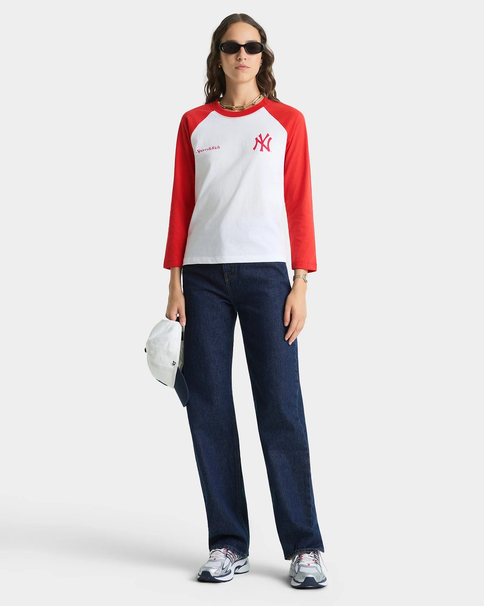 Sporty & Rich Longsleeve am Model in der Ganzkörperansicht. Das Model guckt frontal in die Kamera 