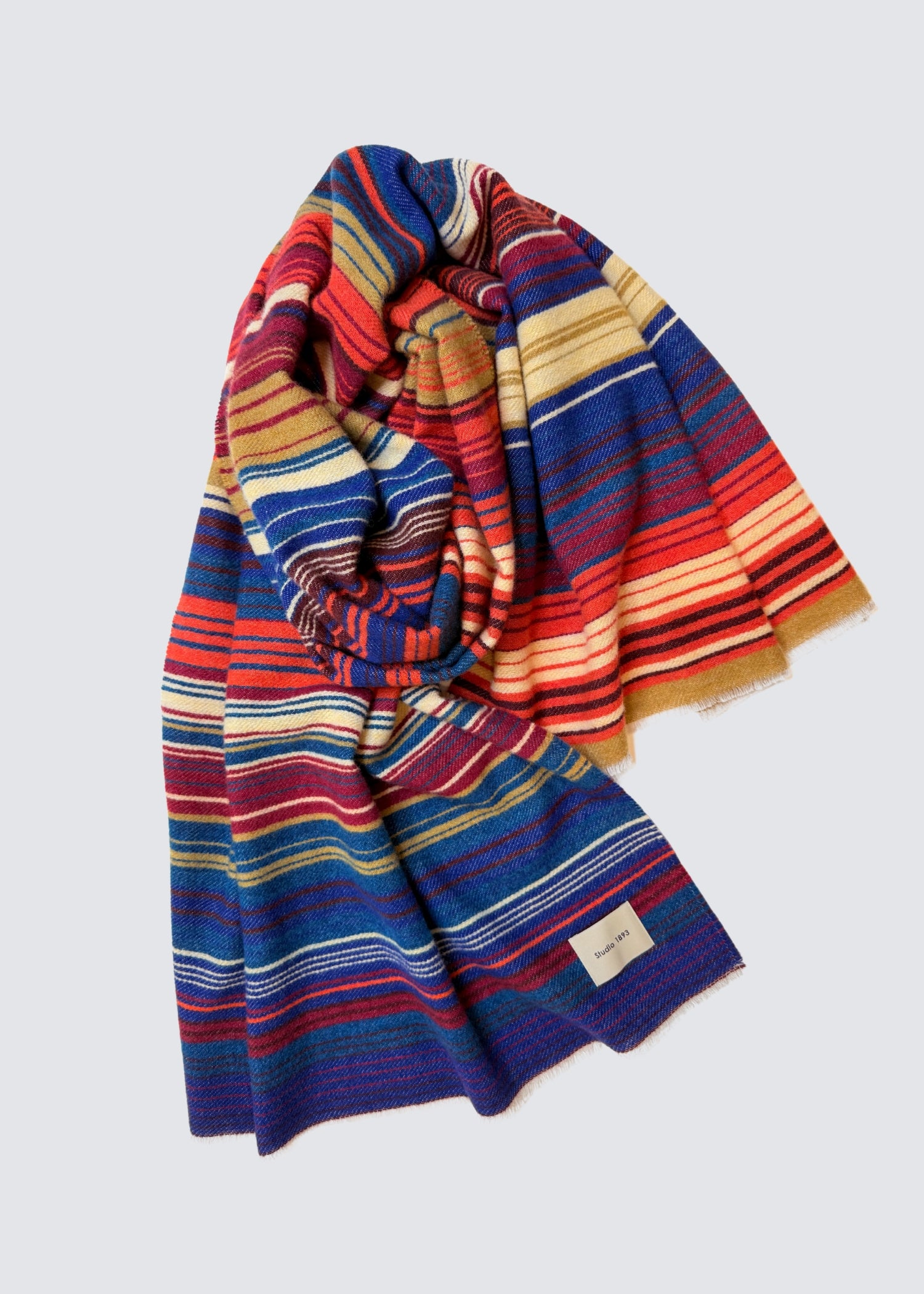 studio 1893 100% Wollschal, mit ausgefranstem Saum. Bunt gestreift. Ocker und Dunkelblau. Flatshot, zusammengelegt.