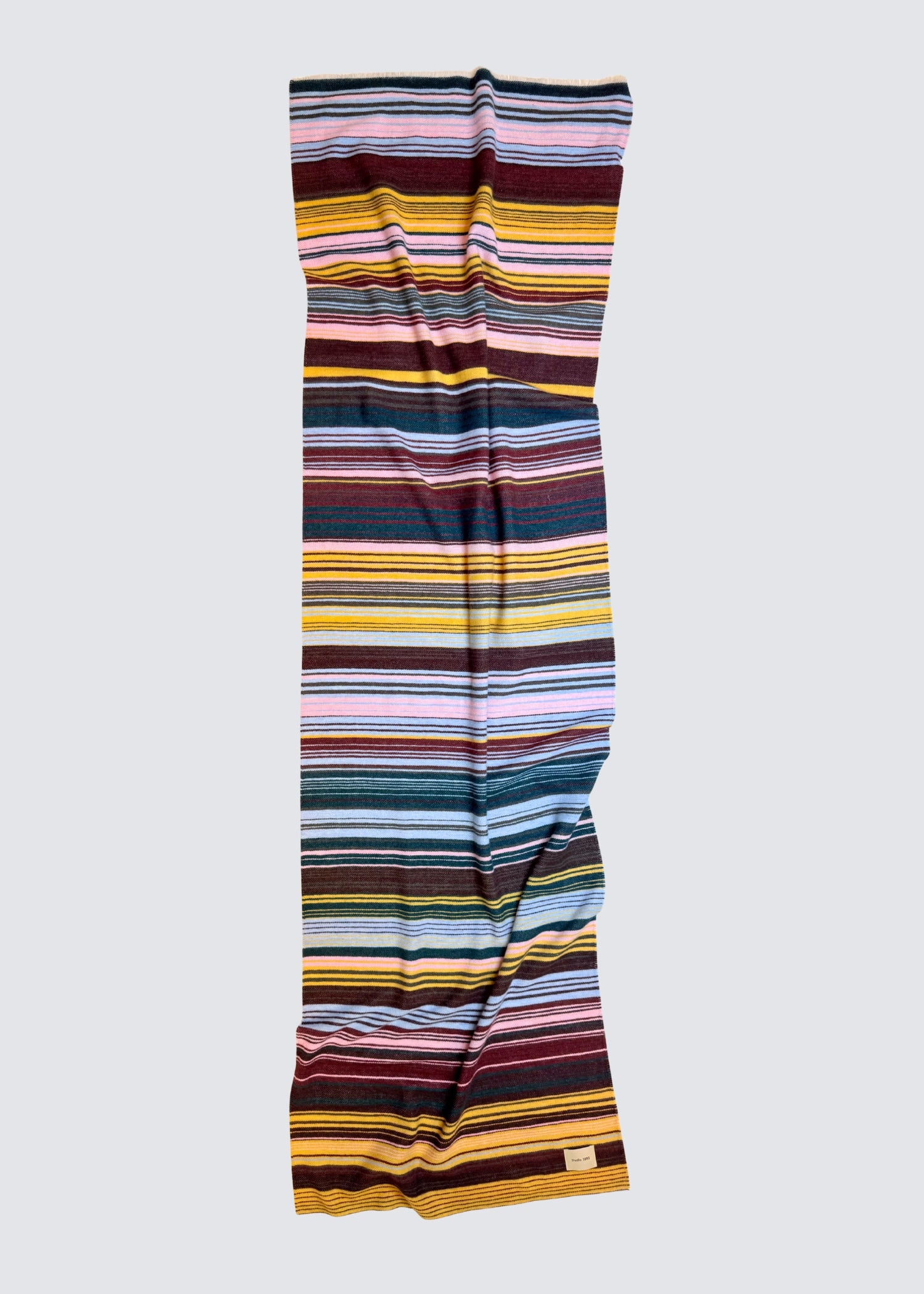 studio 1893 100% Wollschal, mit ausgefranstem Saum. Bunt gestreift. Ocker und Hellblau. Flatshot, ausgebreitet.