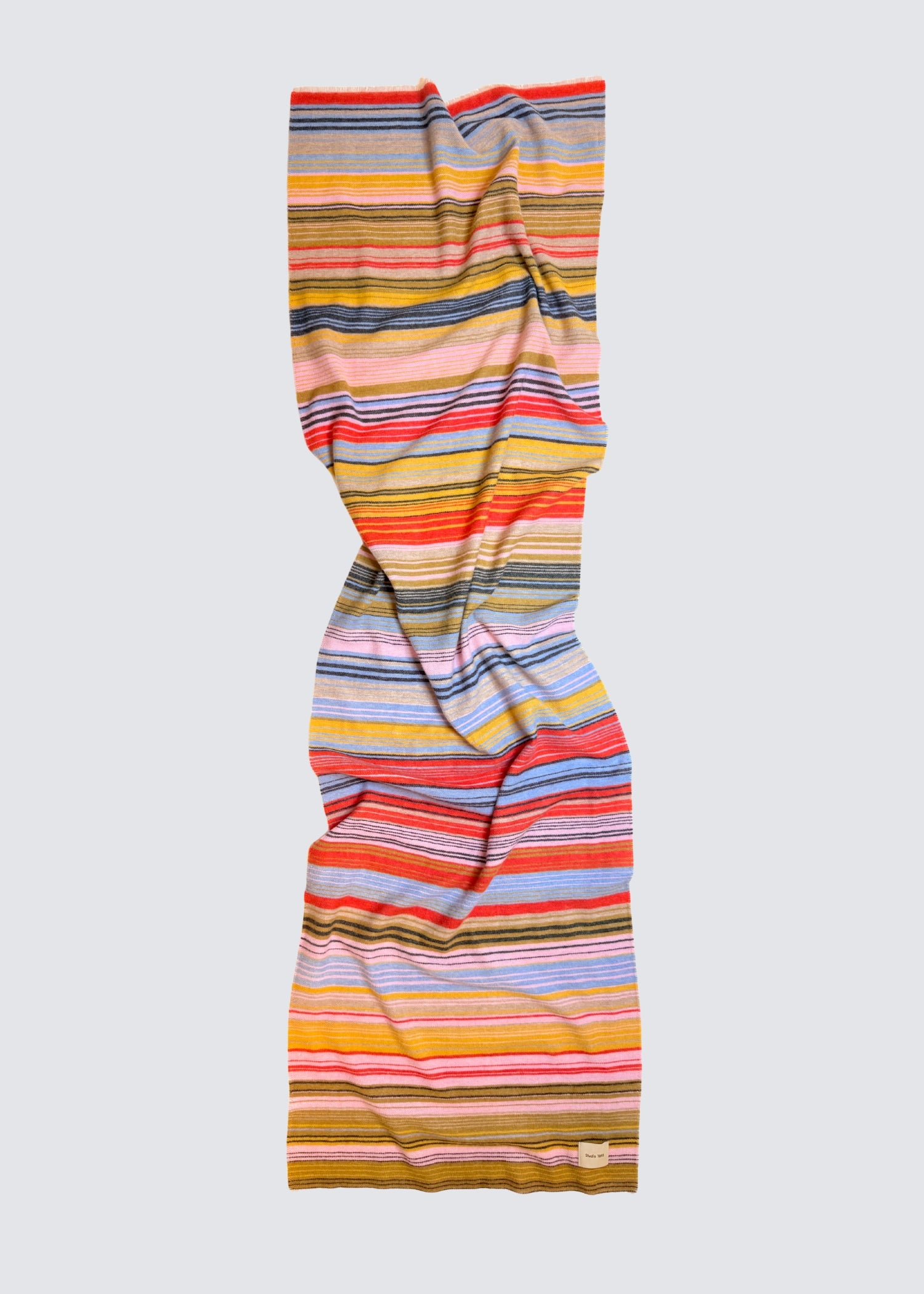 studio 1893 100% Wollschal, mit ausgefranstem Saum. Bunt gestreift. Gelb, grün, rot, blau. Hellere frischere Farben. Flatshot, ausgebreitet.