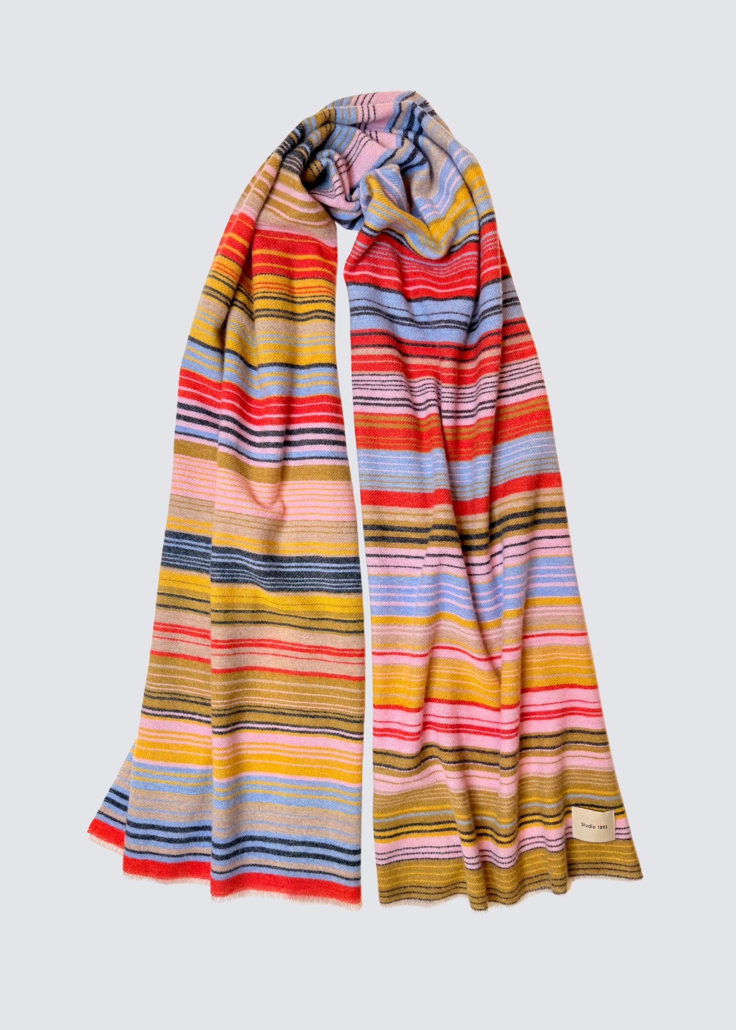 studio 1893 100% Wollschal, mit ausgefranstem Saum. Bunt gestreift. Gelb, grün, rot, blau. Hellere frischere Farben. Flatshot, gewickelt.