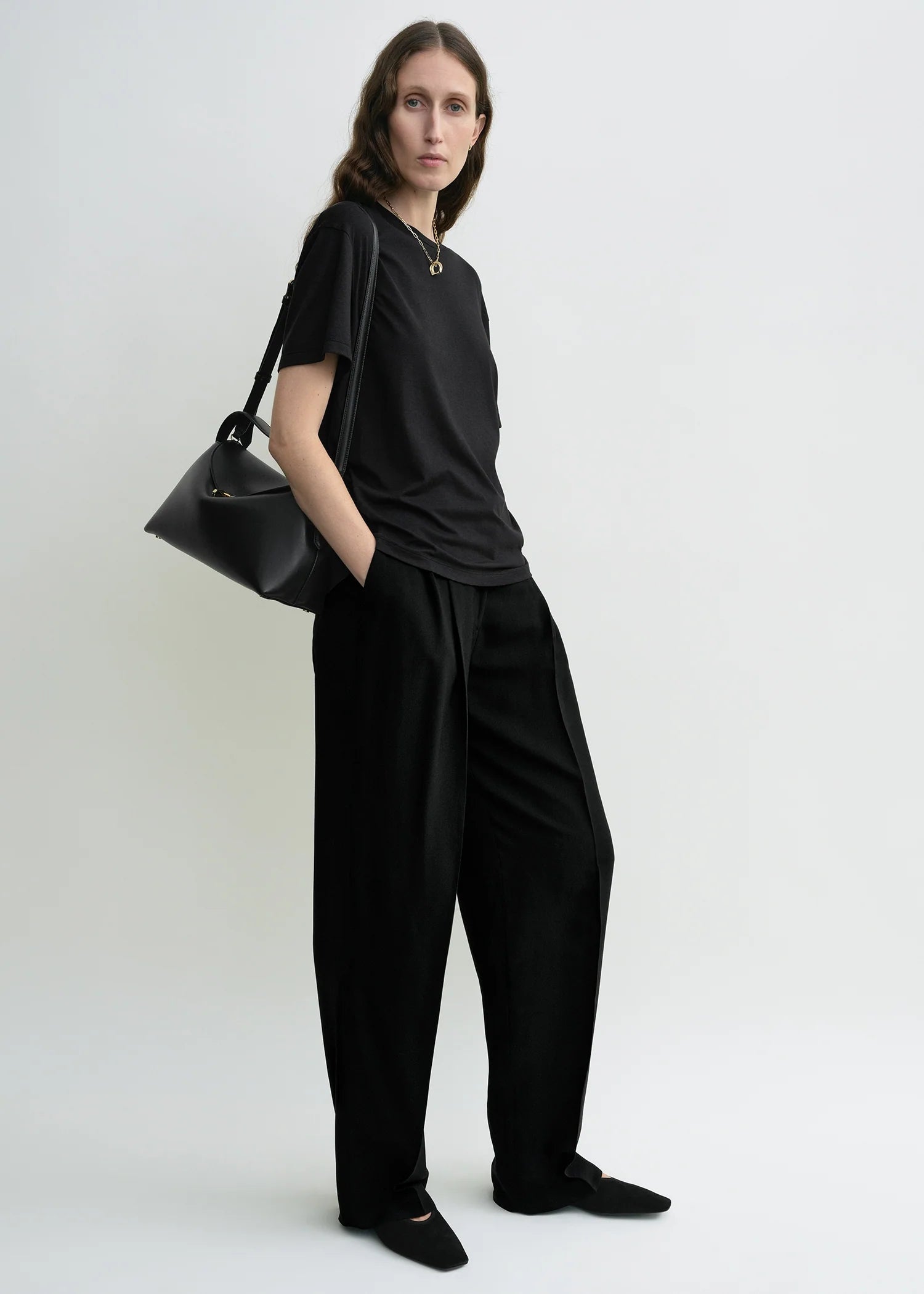 Schwarzes T-Shirt mit Rundhalsausschnitt. Model Bild.