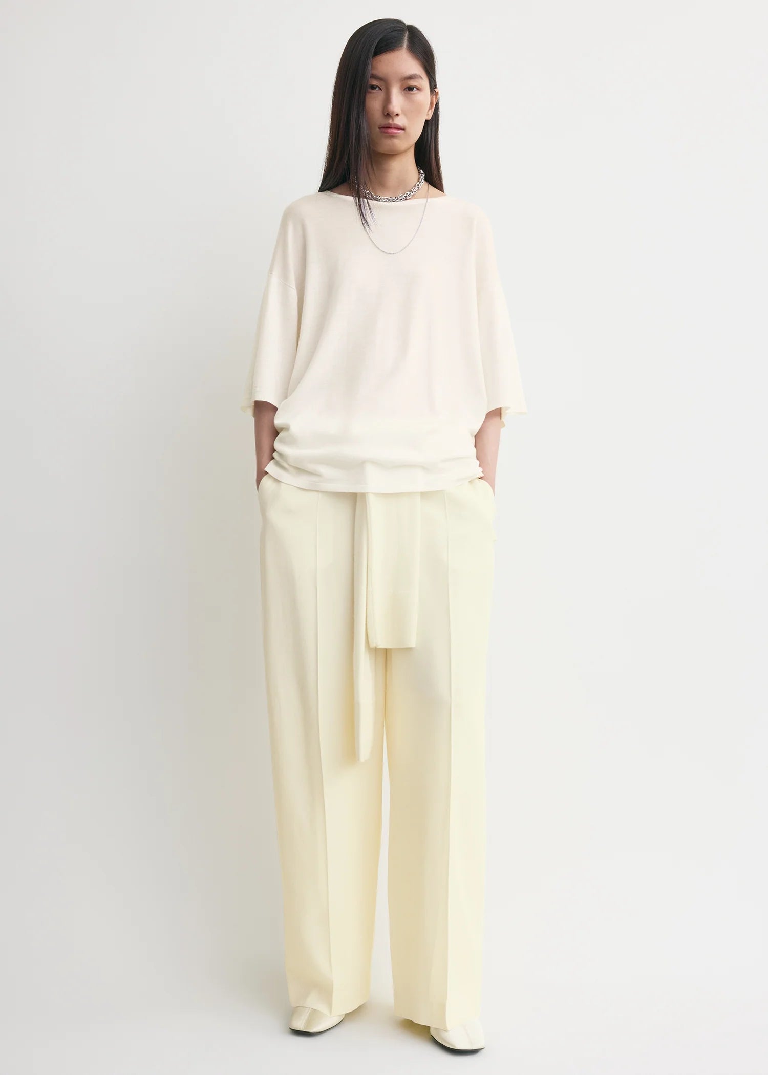 Creme Farbendes, gestricktes T-Shirt mit Rundhalsausschnitt bestehend aus einem Wollgemisch. Model Bild Vorderseite.