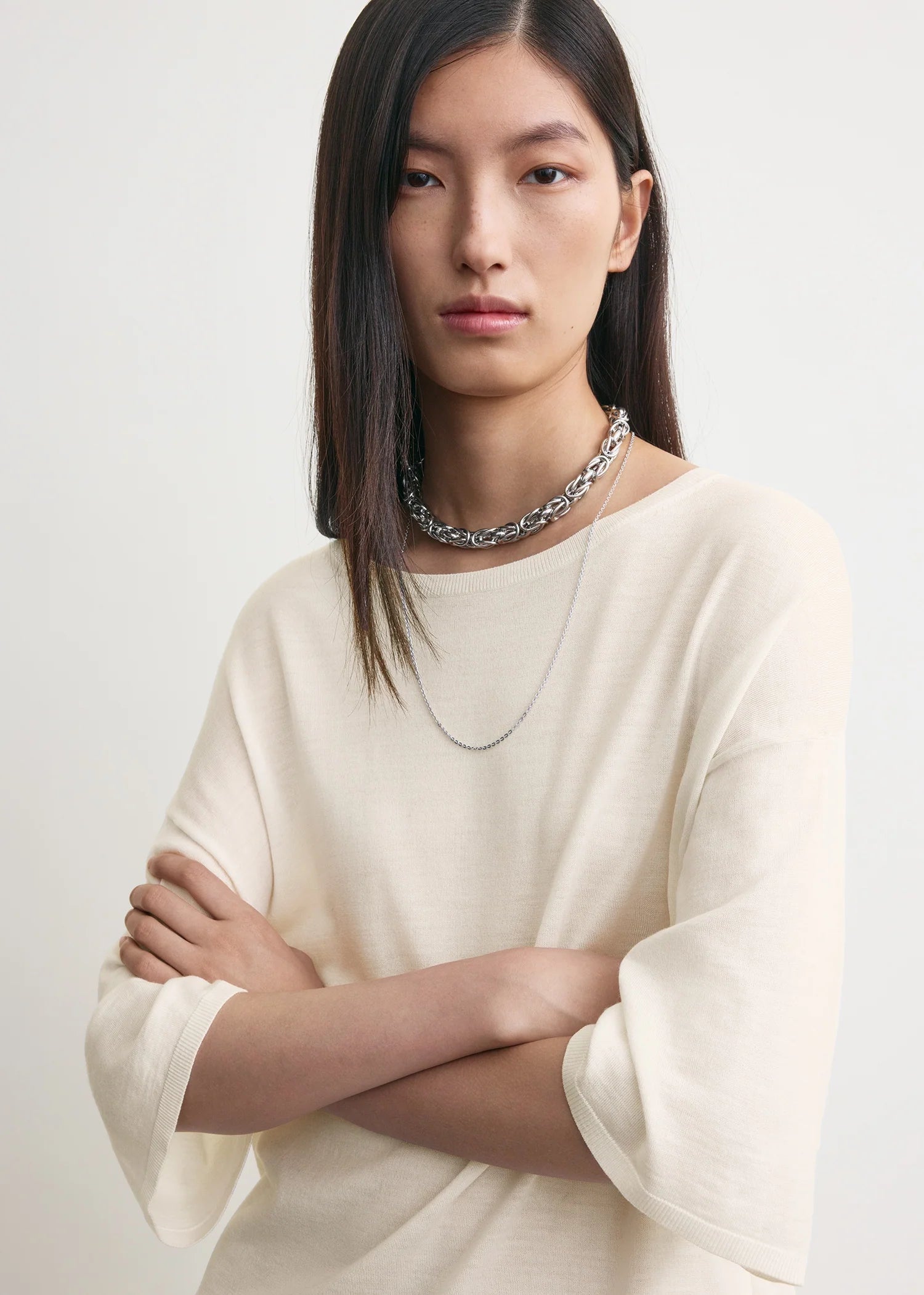 Creme Farbendes, gestricktes T-Shirt mit Rundhalsausschnitt bestehend aus einem Wollgemisch. Detail Shot.