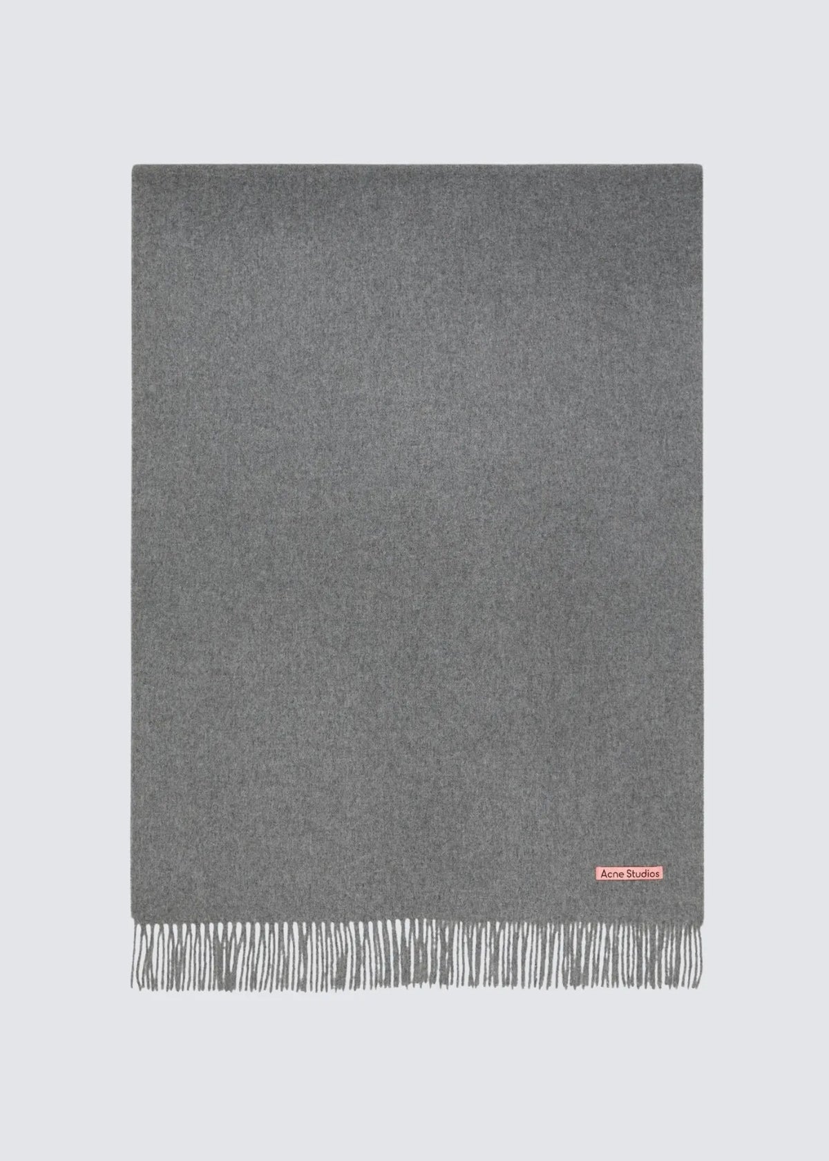 Freistehender Acne Studios Schal in der Farbe Grau von vorne. In der Ecke befindet sich ein Rosa Logo-Etikett mit Acne Studios Schriftzug. Die Enden sind ausgefranst.