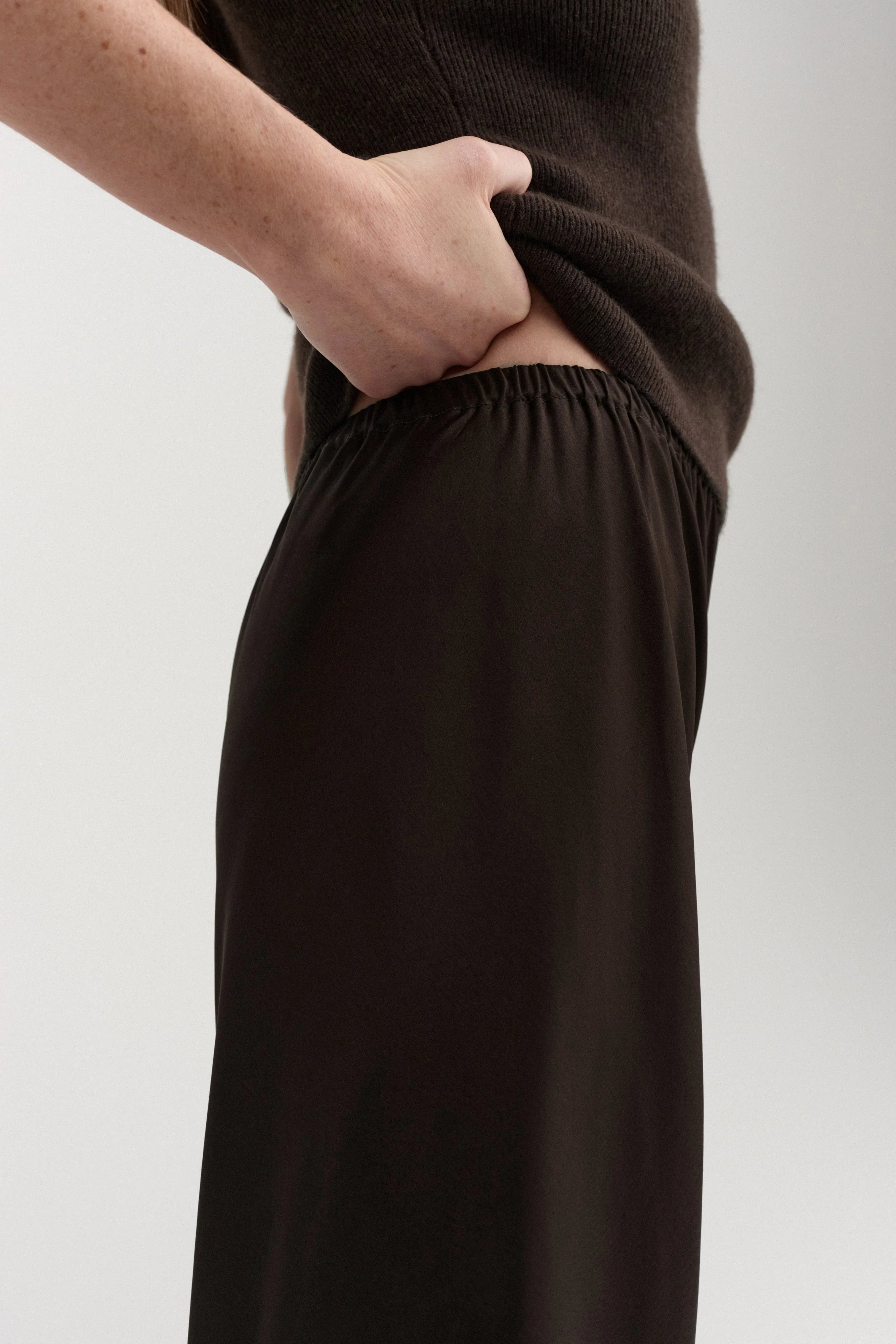 Almada Bias Hose in braun - Satinoptik - Seitenansicht am Model 