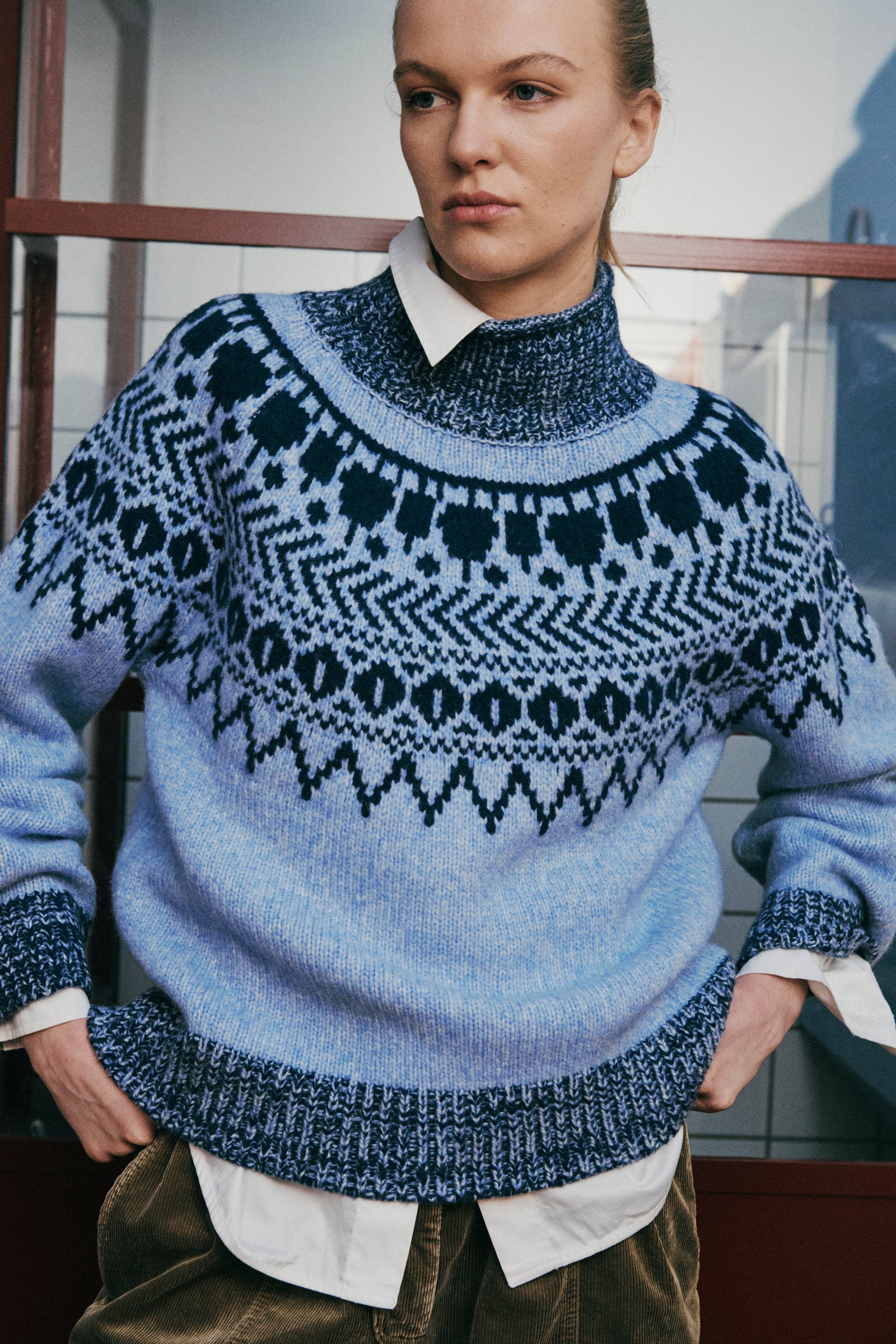 Baum und Pferdgarten blauer Pullover mit Norweger-Muster aus Wollgemisch mit kleinem Stehkragen - Frontalansicht am Model