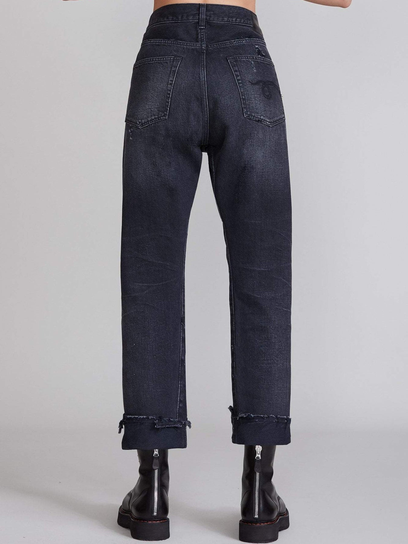 Das Model trägt die R13 Cross Over Jeans in Jake Black. Ansicht von Hinten.