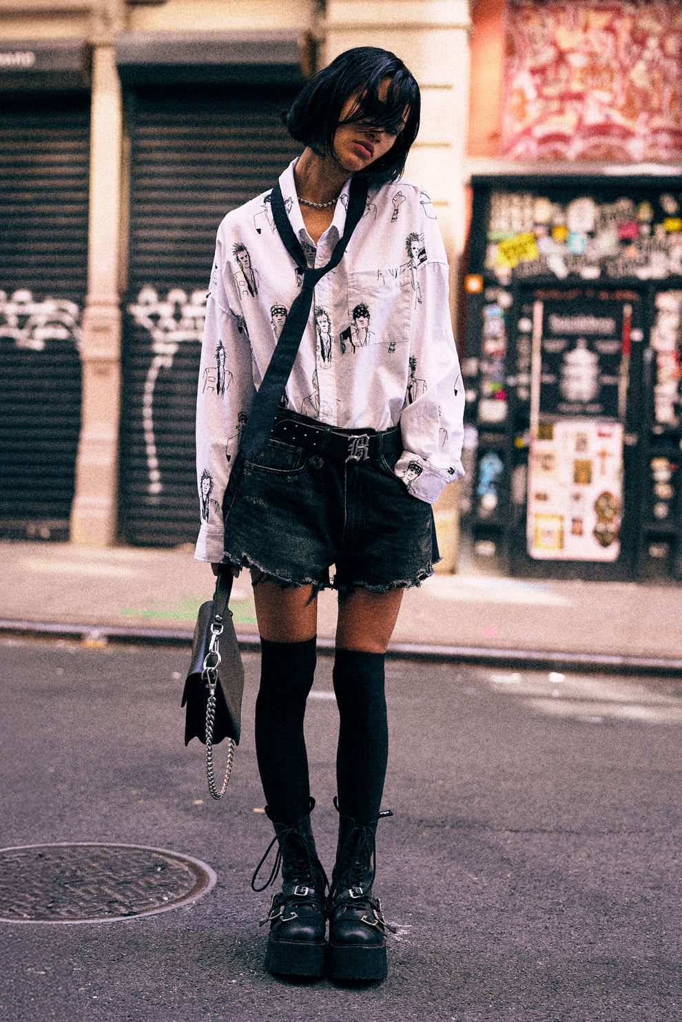 Das Model trägt die R13 Denim Shorts in Marlow Black mit ausgefranstem Saum 