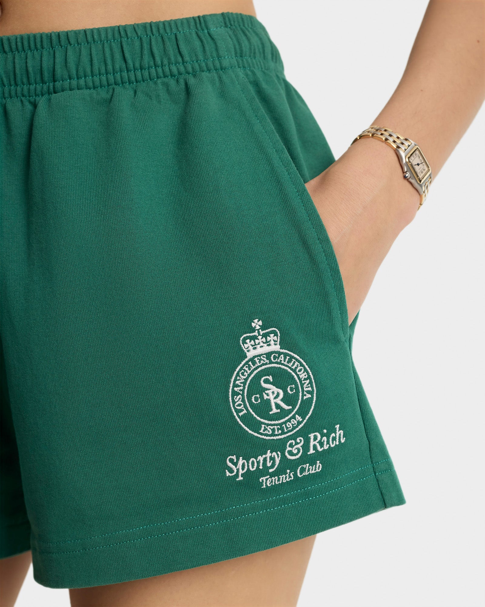 Sporty&Rich grüne Shorts aus Baumwolle - Modelfoto Detailansicht Logo