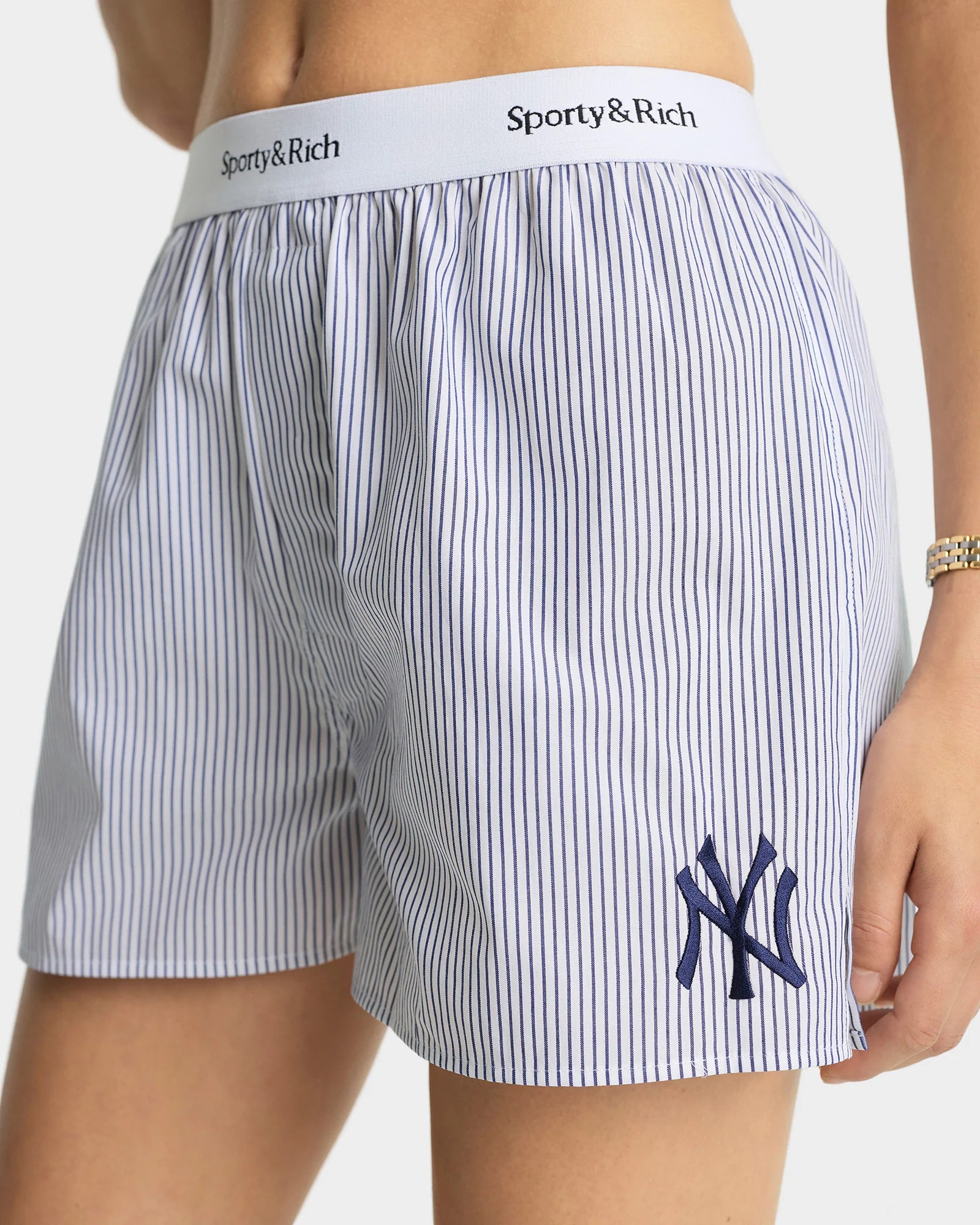Sporty & Rich blau gestreifte Shorts aus Baumwolle - Modelfoto Detailansicht Logo